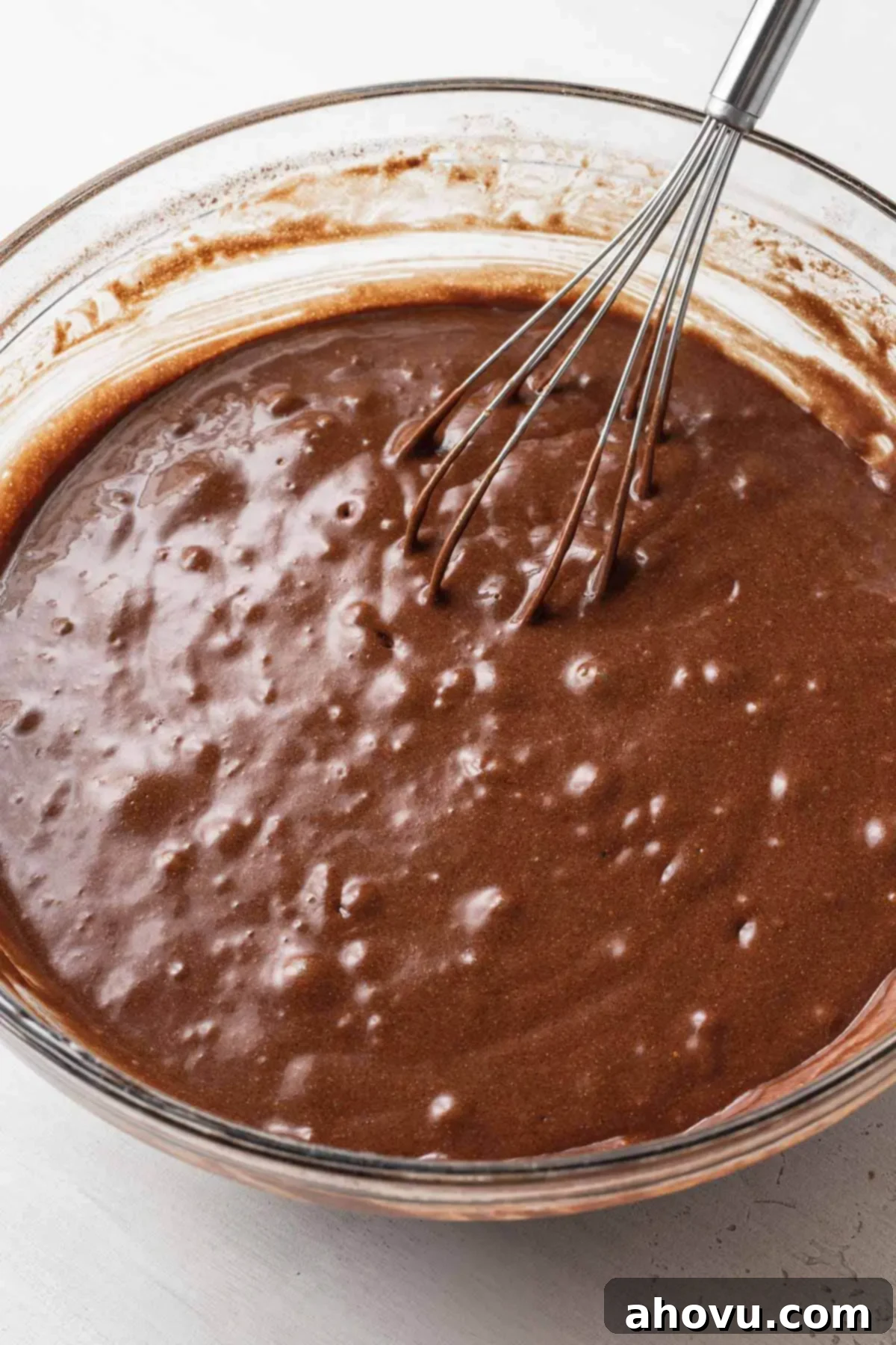 The Ultimate Homemade Ice Cream Cake 9 Thick chocolate cake batter, resembling brownie batter, in a glass mixing bowl with a whisk, before the addition of boiling water.