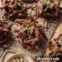 Several haystack cookies topped with red and green sprinkles on a small wire rack.