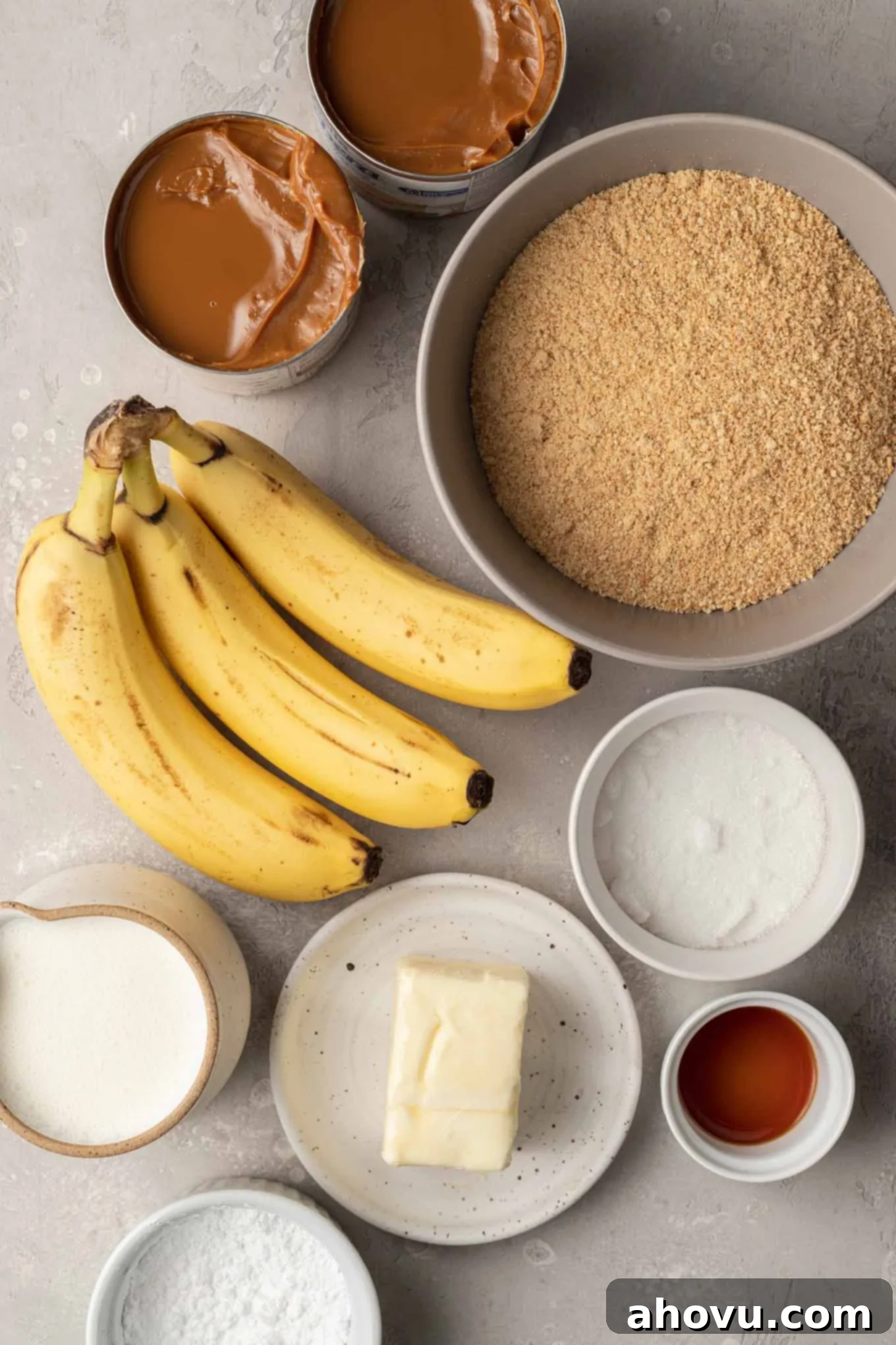 An overhead view of the essential ingredients for banoffee pie arranged artfully on a countertop, highlighting their freshness and quality.