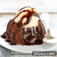 A molten chocolate lava cake topped with ice cream and chocolate sauce, presented on a plate.