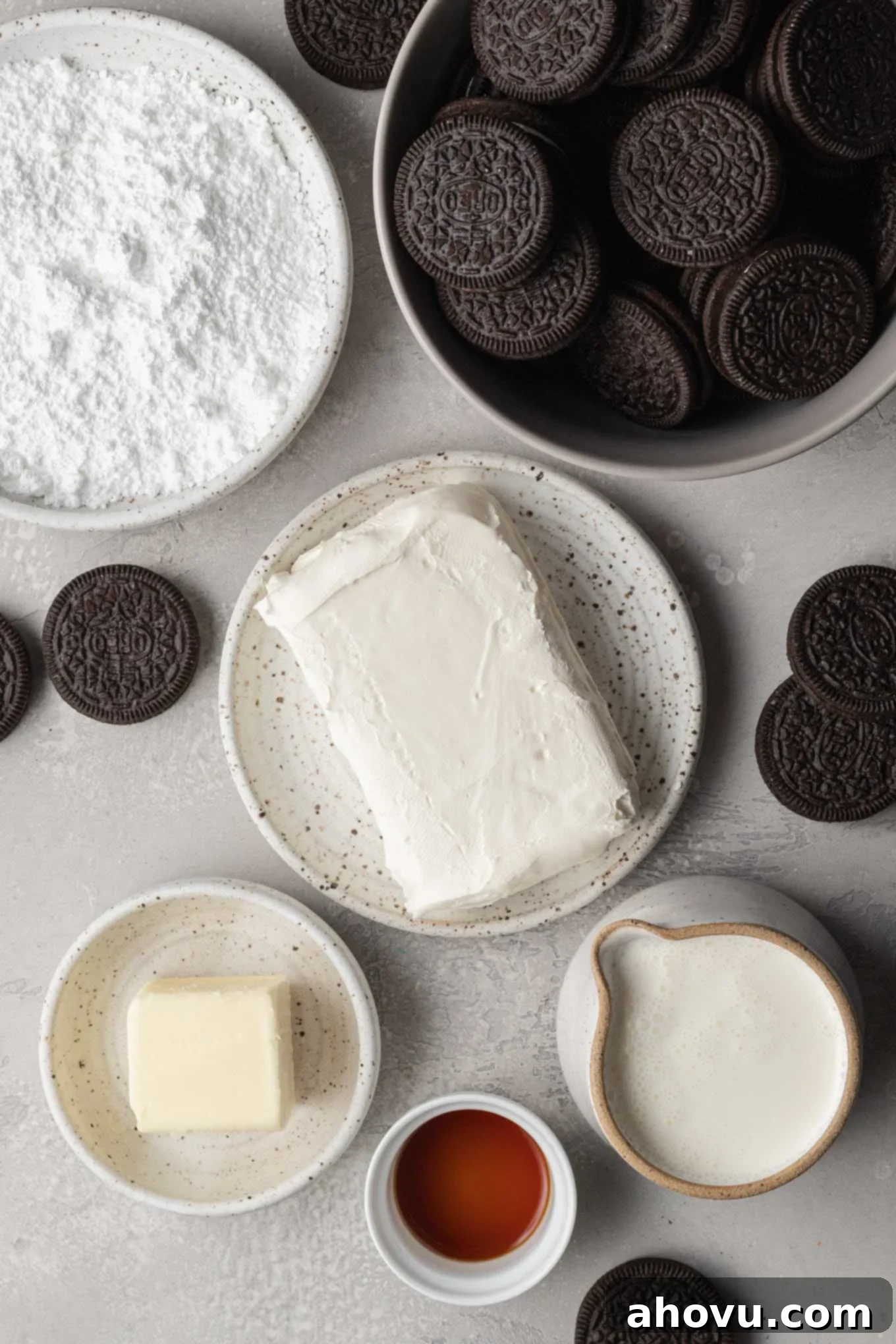 An overhead shot displaying a carefully arranged selection of key ingredients required to prepare a delicious Oreo pie, including Oreos, butter, cream cheese, powdered sugar, heavy whipping cream, and vanilla extract.
