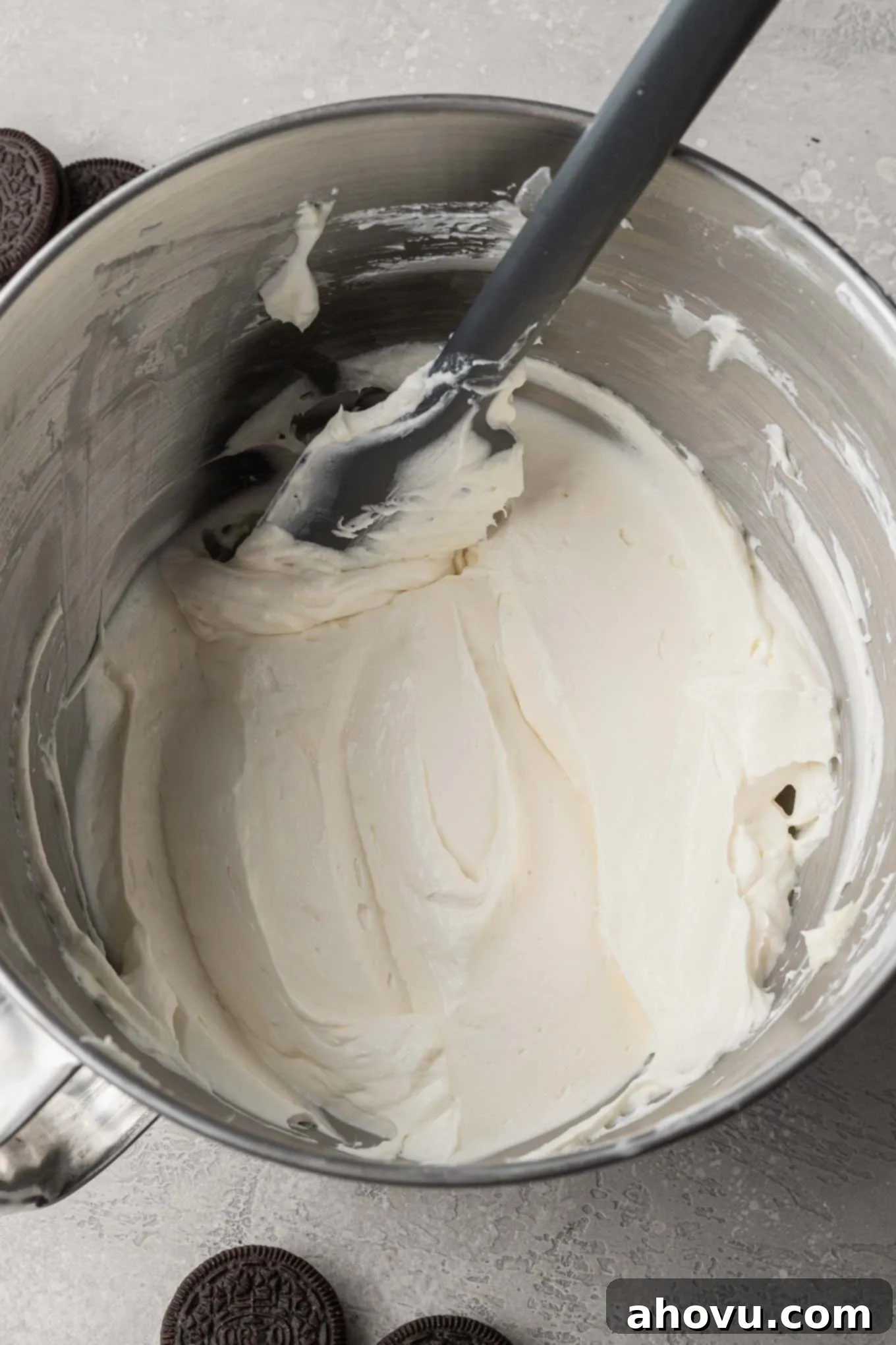 An overhead shot showing the gentle process of folding whipped cream into the rich cream cheese mixture, ensuring a light and airy texture for the pie filling.