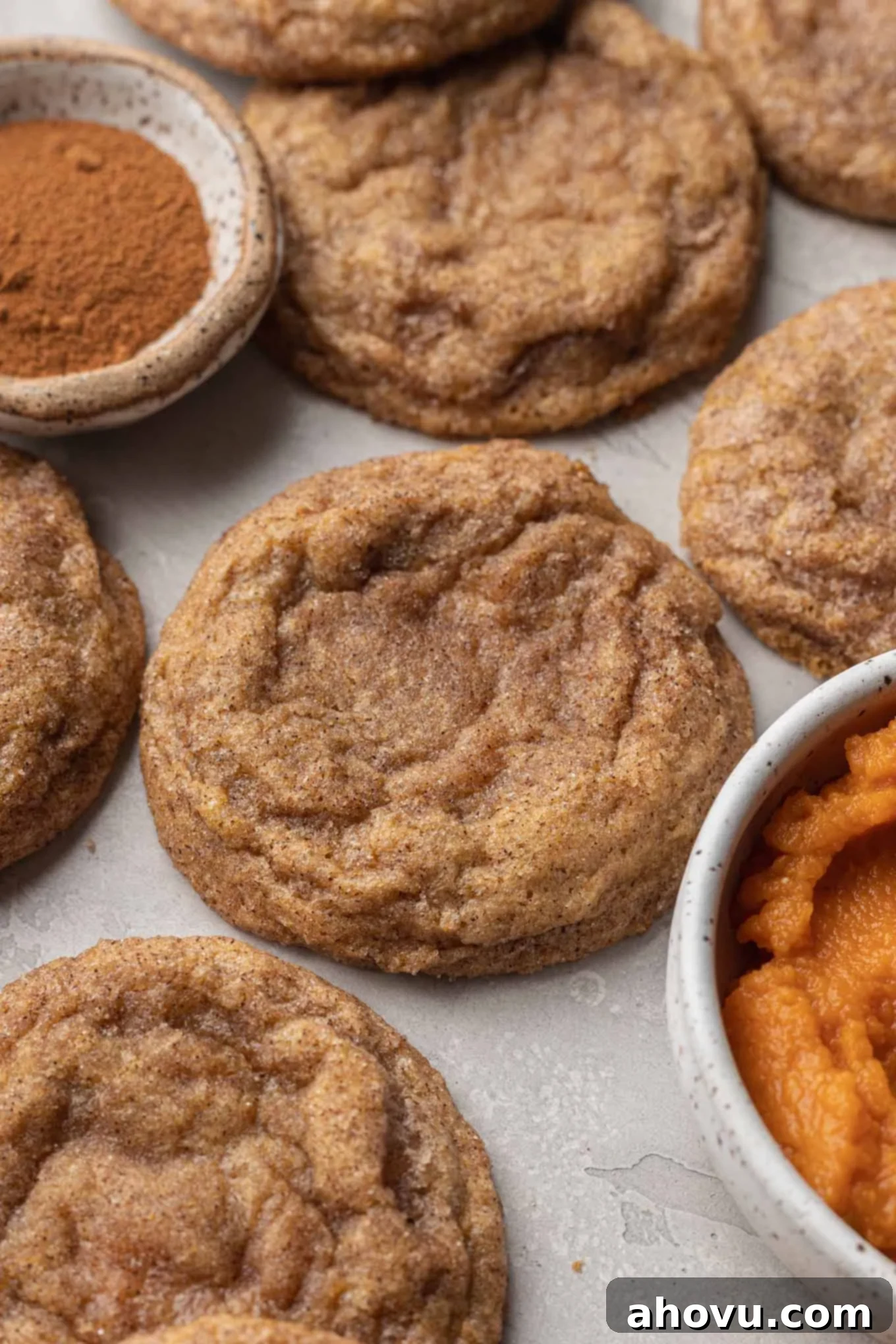 A close-up view of cream cheese-filled pumpkin cookies, next to a dish of pumpkin puree.  