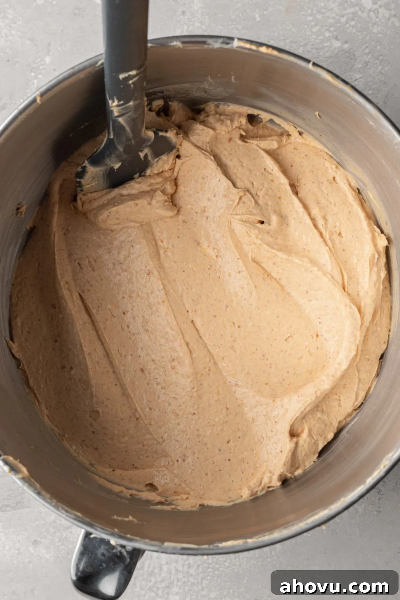 An overhead view of the no-bake pumpkin cheesecake filling in the bowl of a stand mixer, demonstrating its smooth and creamy texture after all ingredients are combined.
