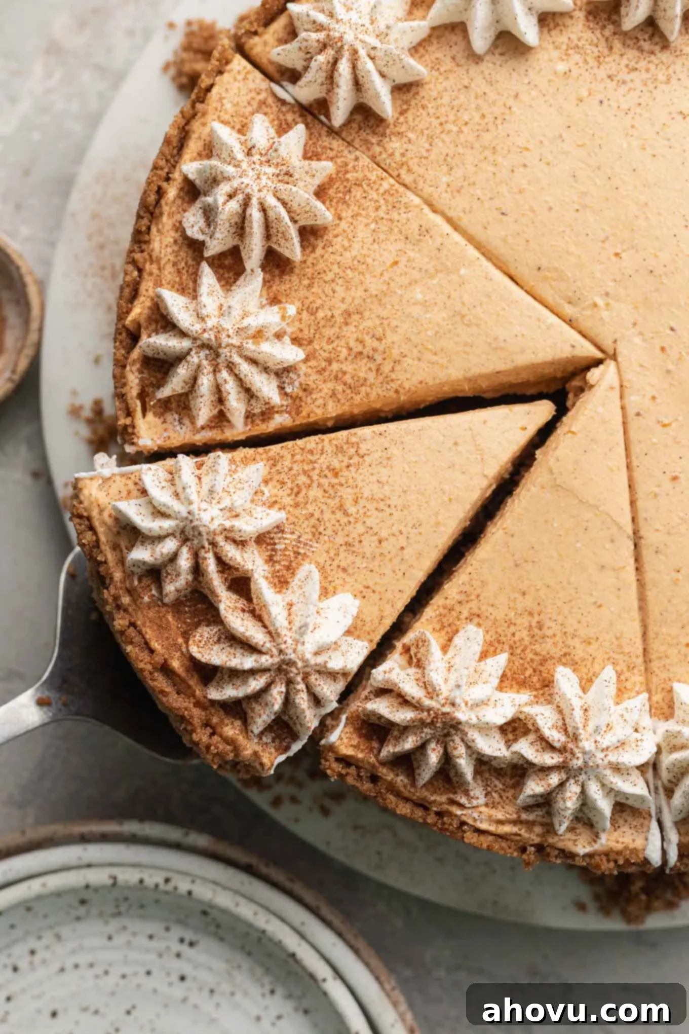 An overhead view of a beautifully sliced no-bake pumpkin cheesecake, showing its distinct layers and creamy texture.