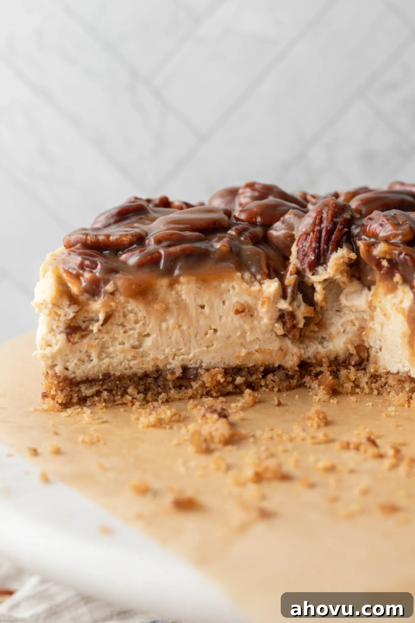 A pecan pie cheesecake, sliced and shown from the side. 