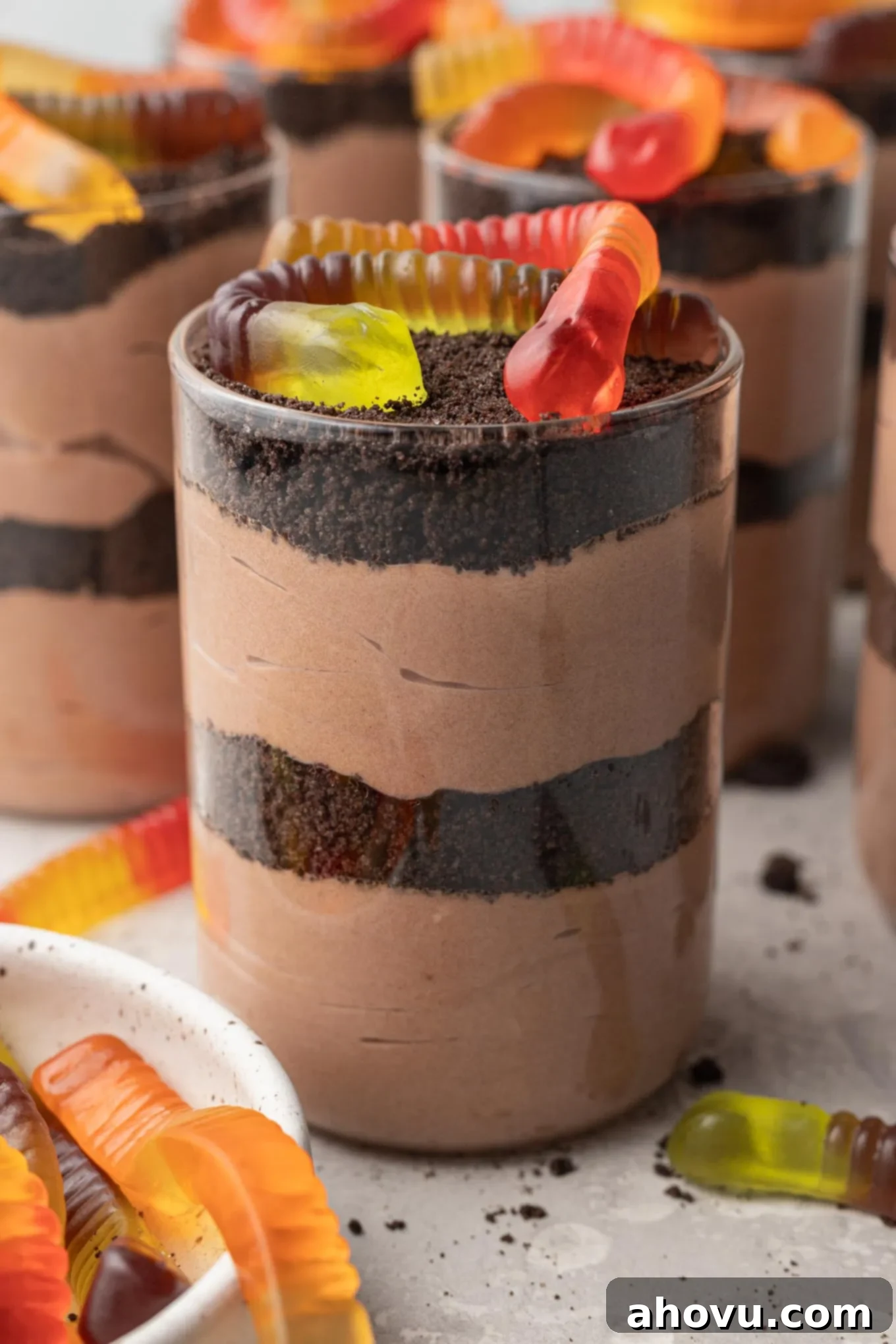 Layered Oreo dirt cups with gummy worms on top, ready to be enjoyed.