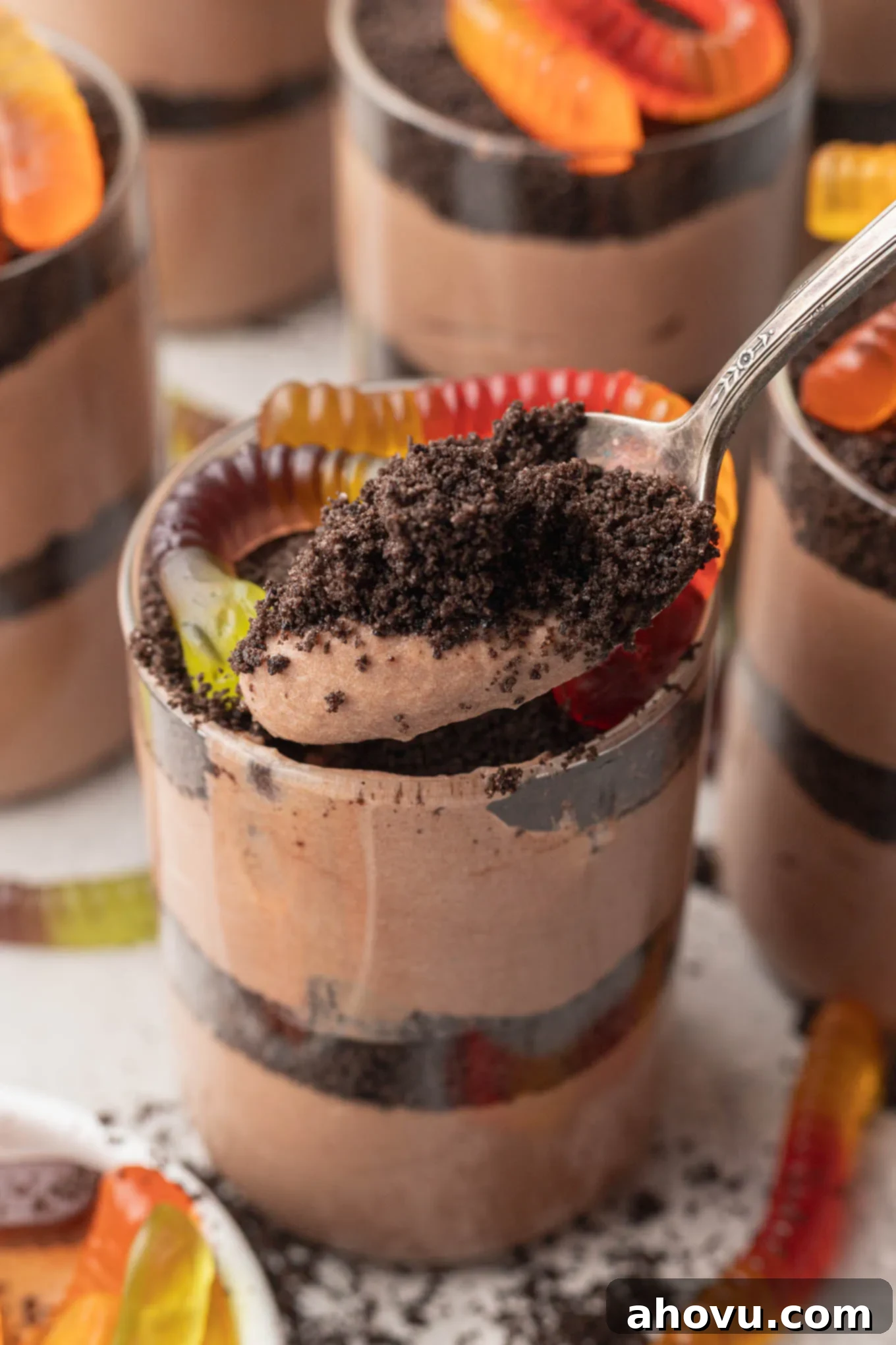 A spoonful of rich chocolate pudding and crushed Oreo crumbs, taken from a perfectly layered dirt cup.
