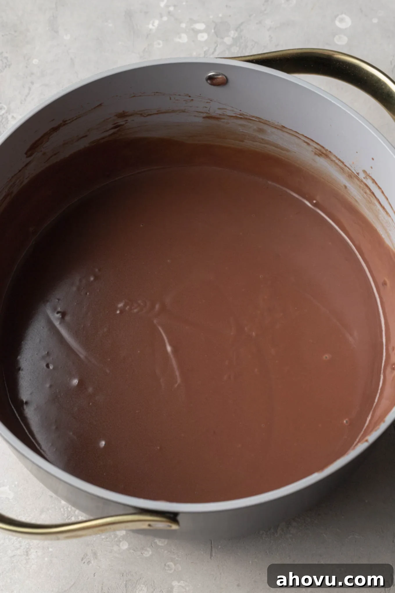 An overhead view of homemade chocolate pudding simmering in a saucepan.