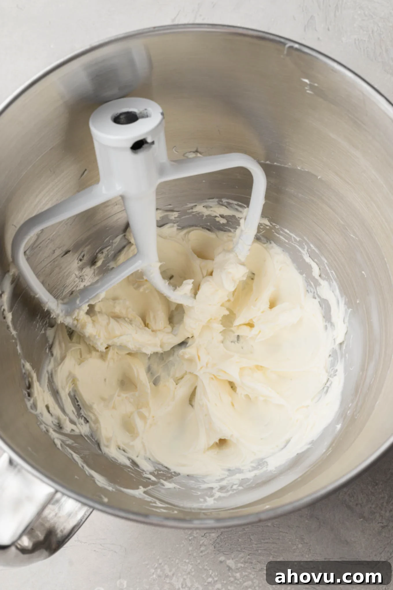Creamy Dream Mints 4 An overhead view of softened cream cheese and butter being beaten in a stand mixer with a paddle attachment, creating a smooth base for the mints.