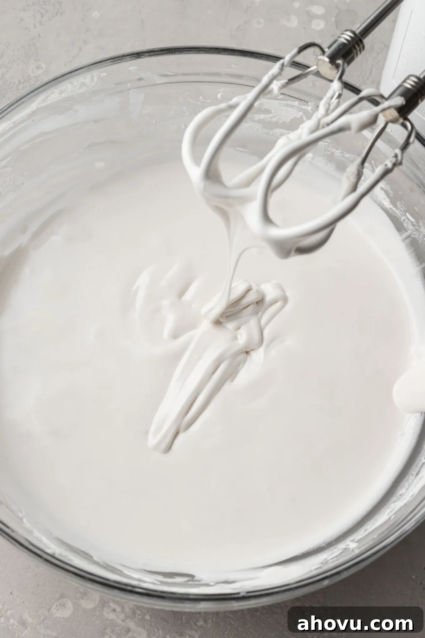 A mixing bowl filled with royal icing, perfectly thinned to flood consistency, smooth and ready for filling large areas.