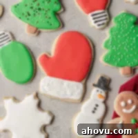 An overhead view of several sugar cookies topped with royal icing, showcasing various designs and colors.