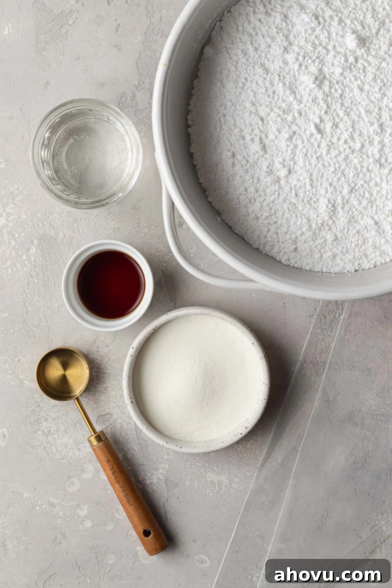 An overhead shot showcasing all the essential ingredients laid out neatly for crafting homemade royal icing, including powdered sugar, meringue powder, corn syrup, water, and vanilla extract.
