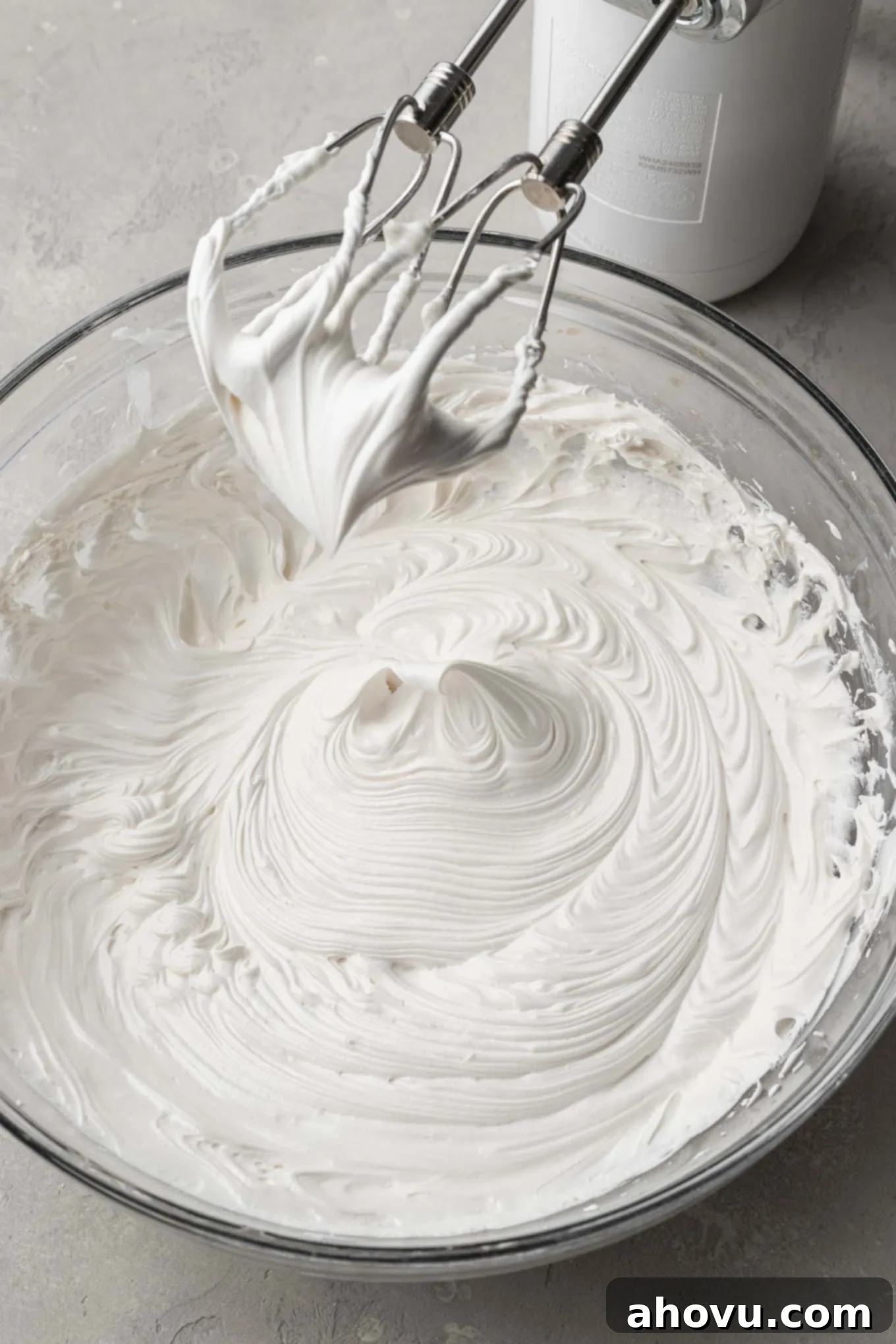 A pristine bowl of royal icing, perfectly beaten to stiff peaks, standing tall and firm for intricate details.