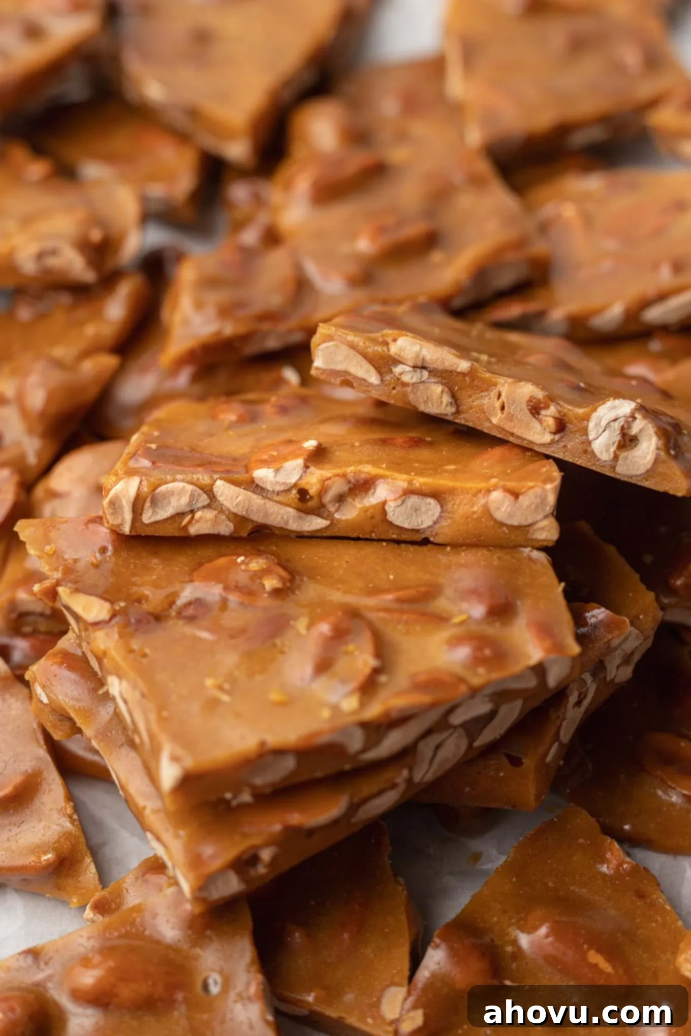 Golden Peanut Brittle 9 Broken pieces of brittle resting on each other, showing their thin, golden texture.