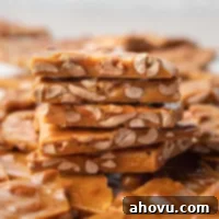 Golden Peanut Brittle 10 Several piece of peanut brittle stacked on top of each other.