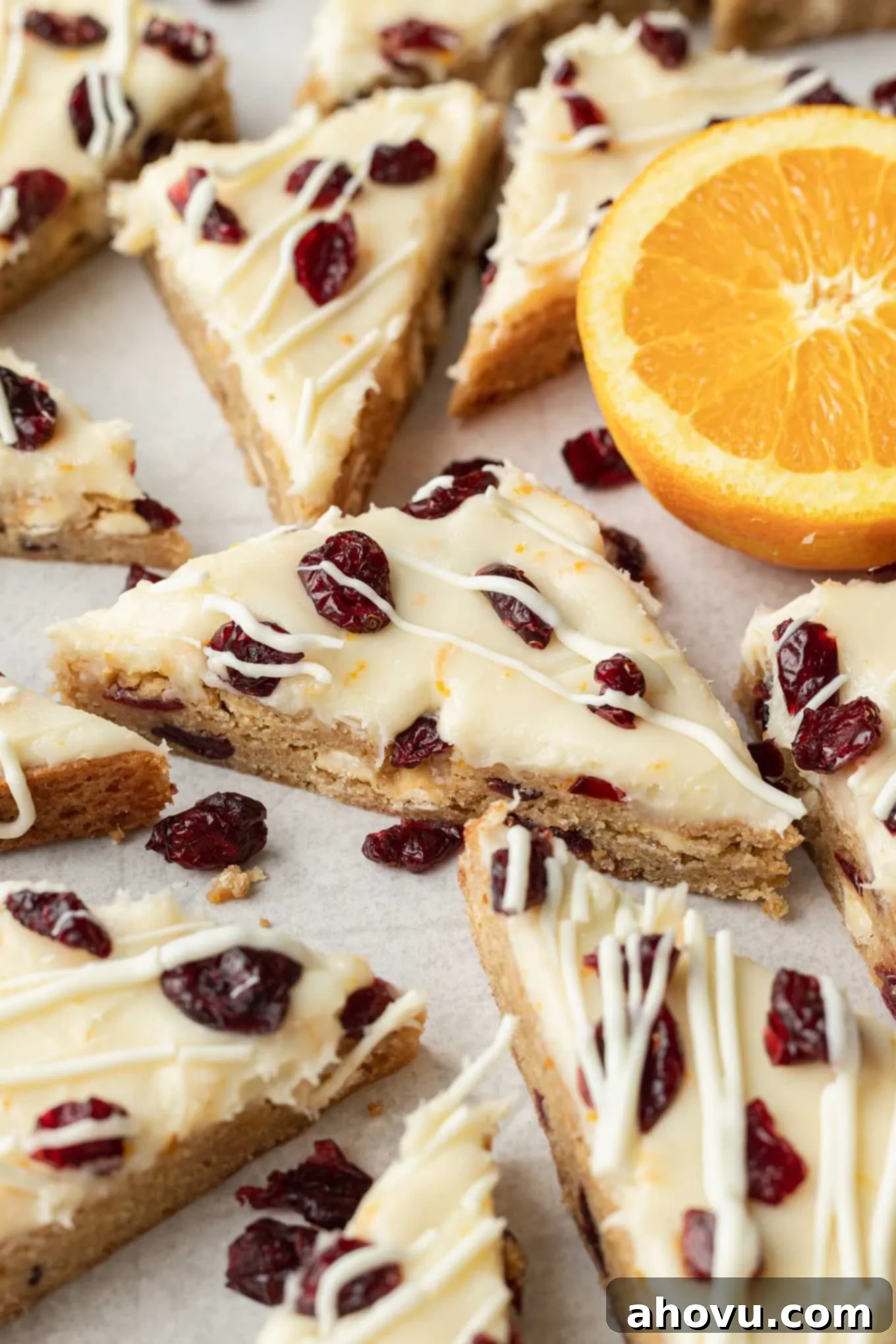 A beautiful arrangement of sliced copycat Starbucks cranberry bliss bars, meticulously cut into triangles and laid out on parchment paper, ready to be served or stored, highlighting their appealing presentation.