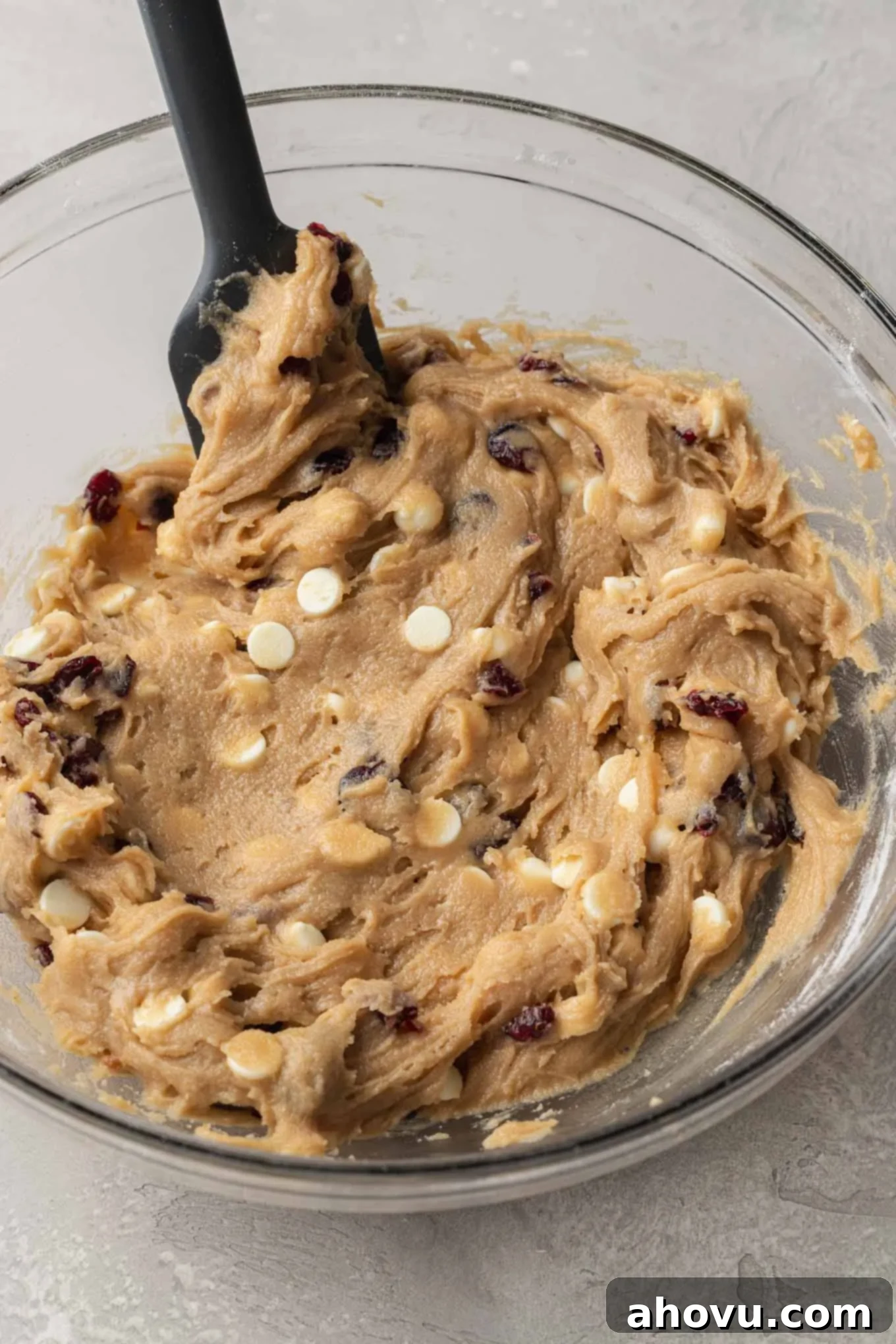 An overhead view of the completed cranberry bliss bar batter in a mixing bowl, showcasing the integrated white chocolate chips and dried cranberries, perfectly ready for baking.