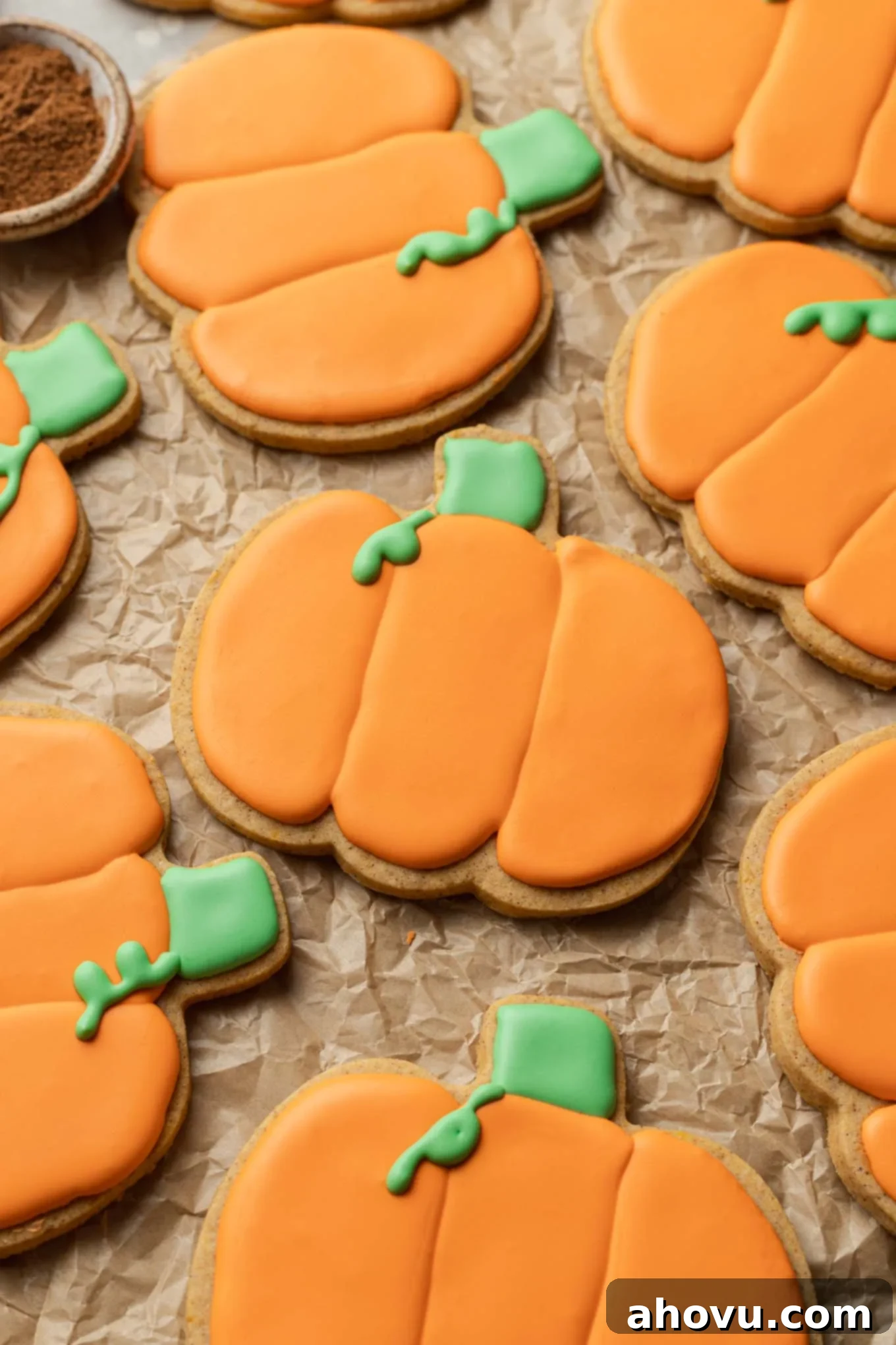 Autumn Pumpkin Sugar Cookies 12 A close-up, overhead view of pumpkin sugar cookies on parchment paper.