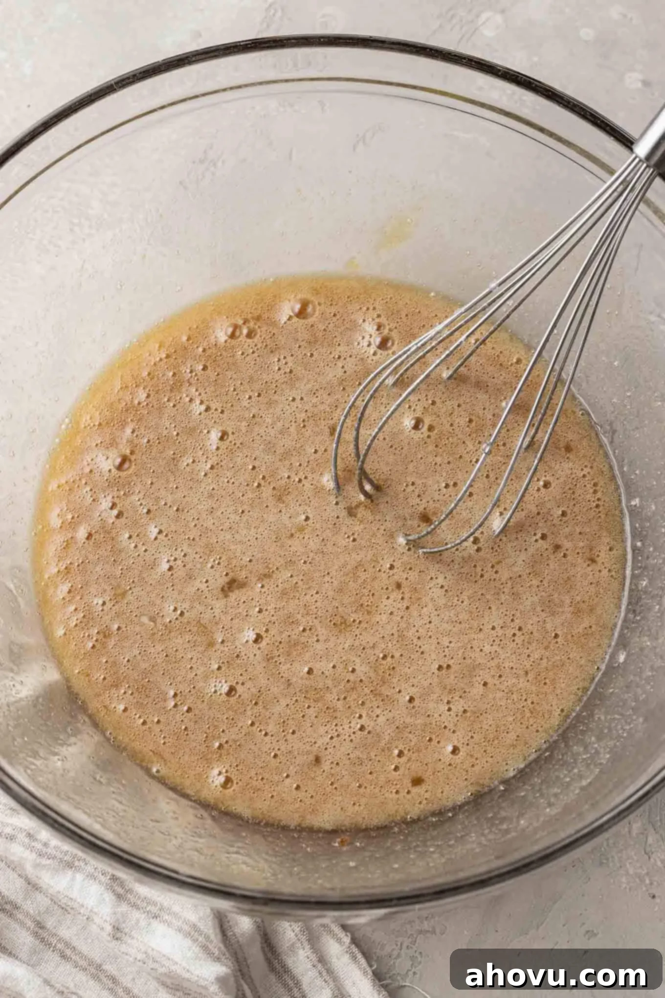 Decadent Chocolate Pecan Dream 8 An overhead view of the silky-smooth custard filling ingredients for pecan pie in a clear glass mixing bowl, with a whisk resting inside, ready for the next step.