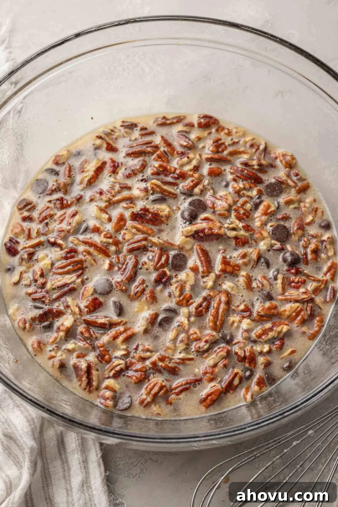 Decadent Chocolate Pecan Dream 9 An overhead view of the luscious pecan chocolate pie filling, rich with pecans and chocolate chips, in a large glass mixing bowl, perfectly combined.