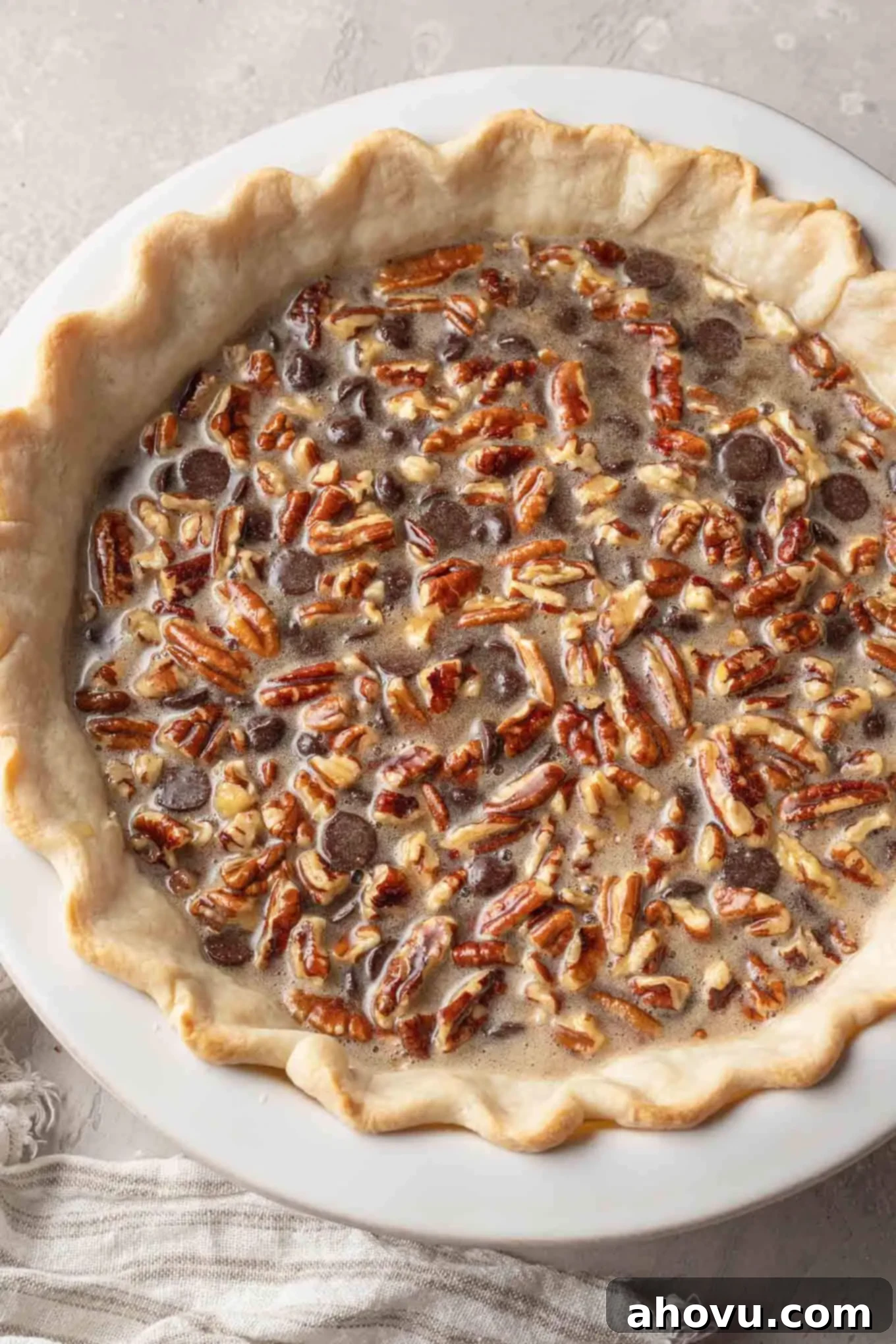 Decadent Chocolate Pecan Dream 10 An overhead view of an unbaked chocolate pecan pie, with the rich filling poured into the partially baked crust, ready for its final bake.