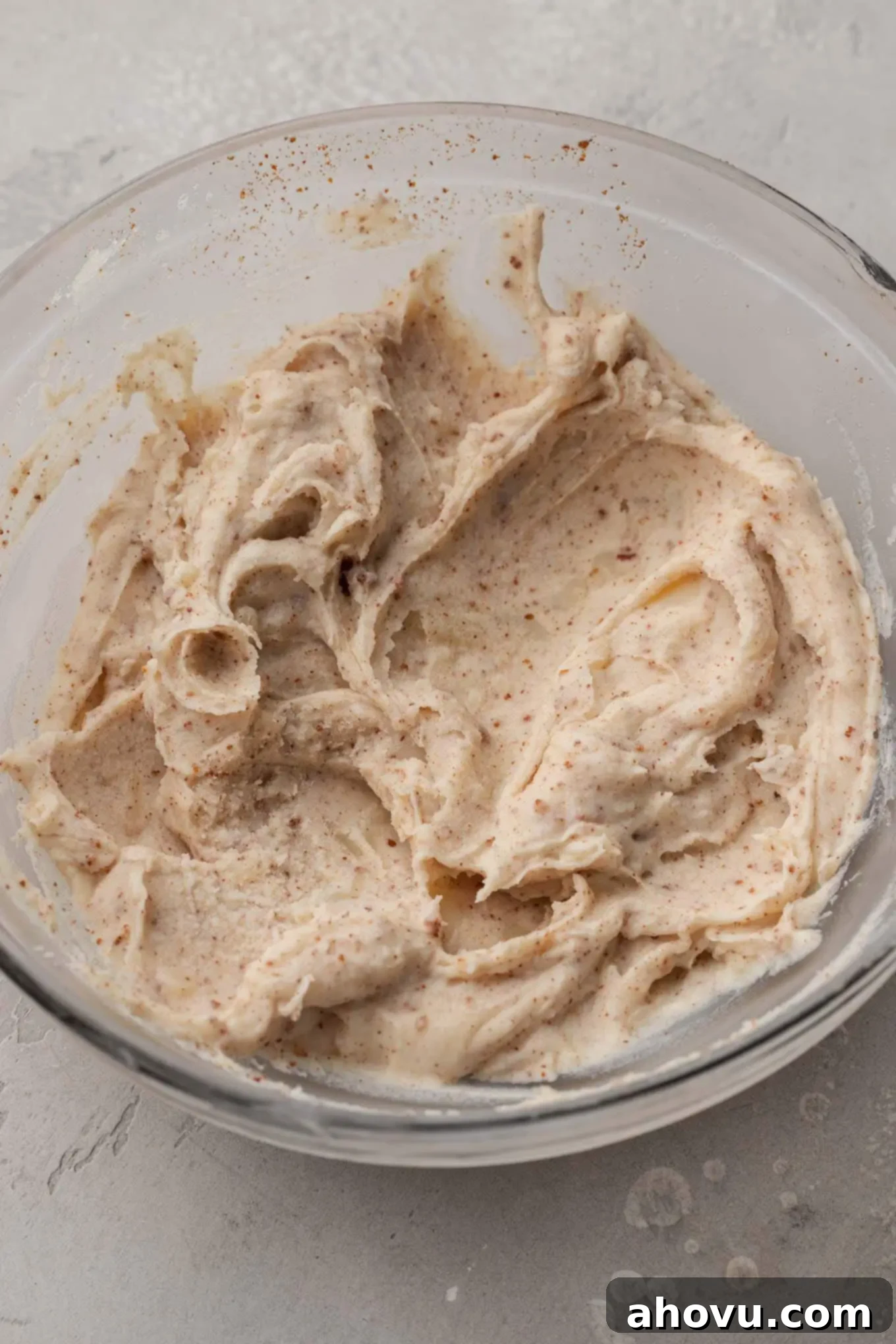 An overhead view of solidified browned butter in a glass mixing bowl. 