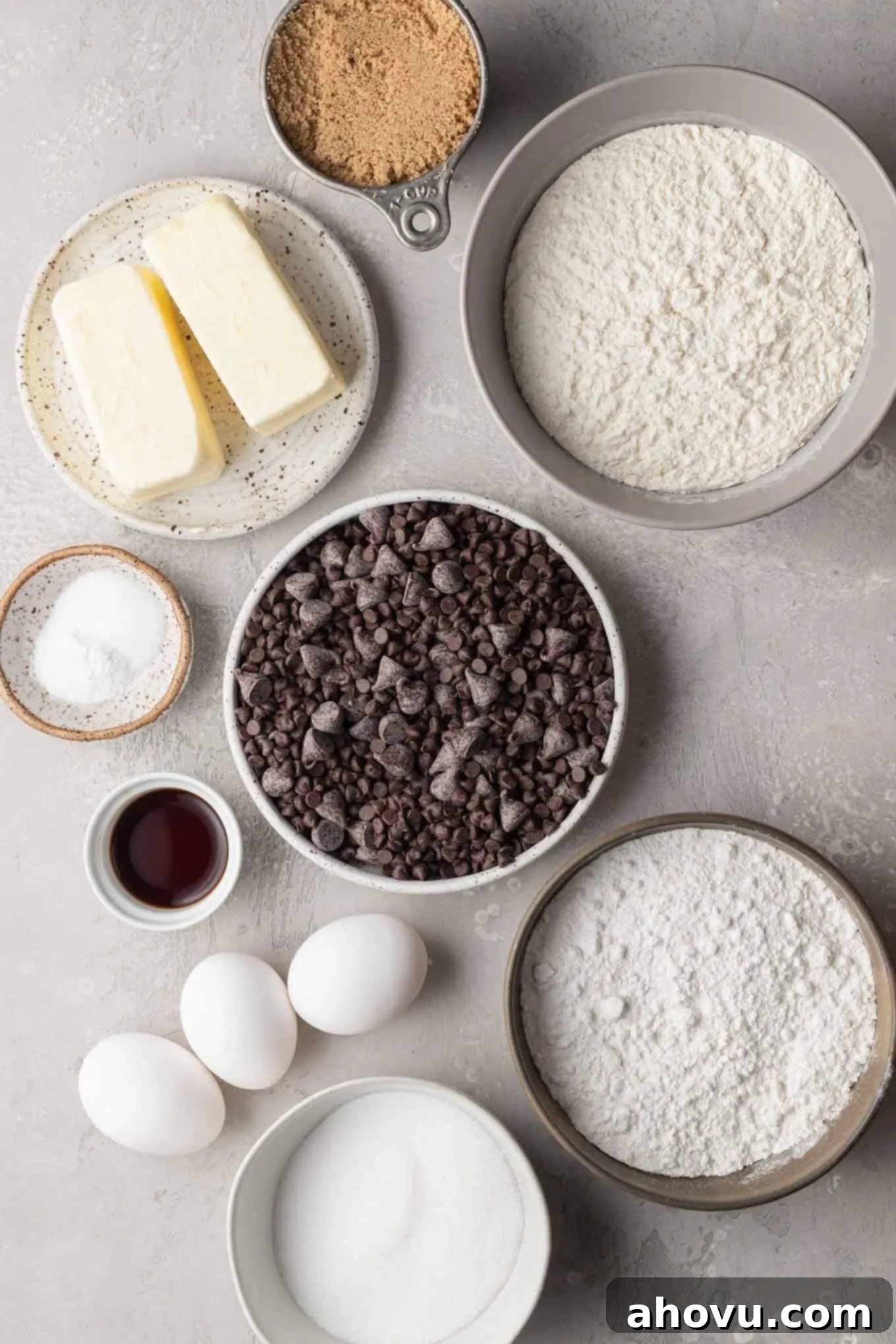 An overhead view of the ingredients needed to make these chocolate chip cookies in various bowls and measuring cups.