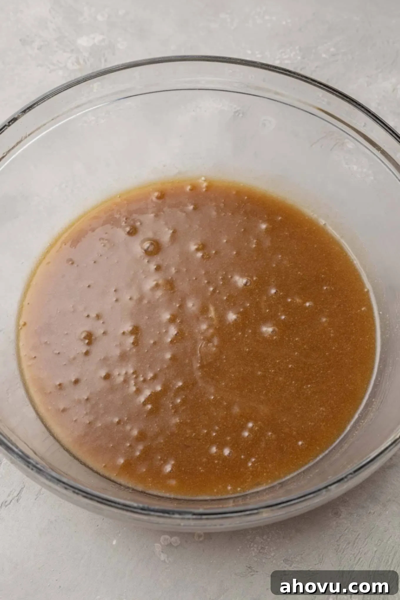 A glass mixing bowl with the wet ingredients mixed together.