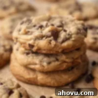 Three thick bakery style chocolate chip cookies stacked on top of each other.
