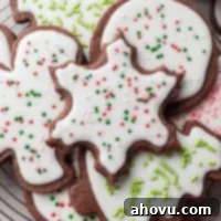 Several iced chocolate sugar cookies on a wire cooling rack.