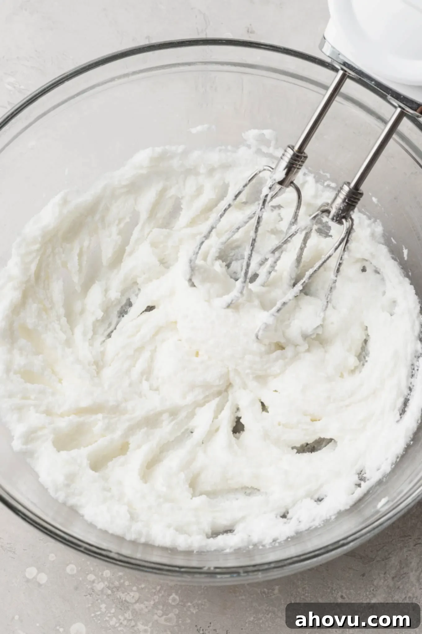 An overhead view of creamy shortening and granulated sugar being perfectly creamed together in a glass mixing bowl, a crucial step for tender sugar cookies.