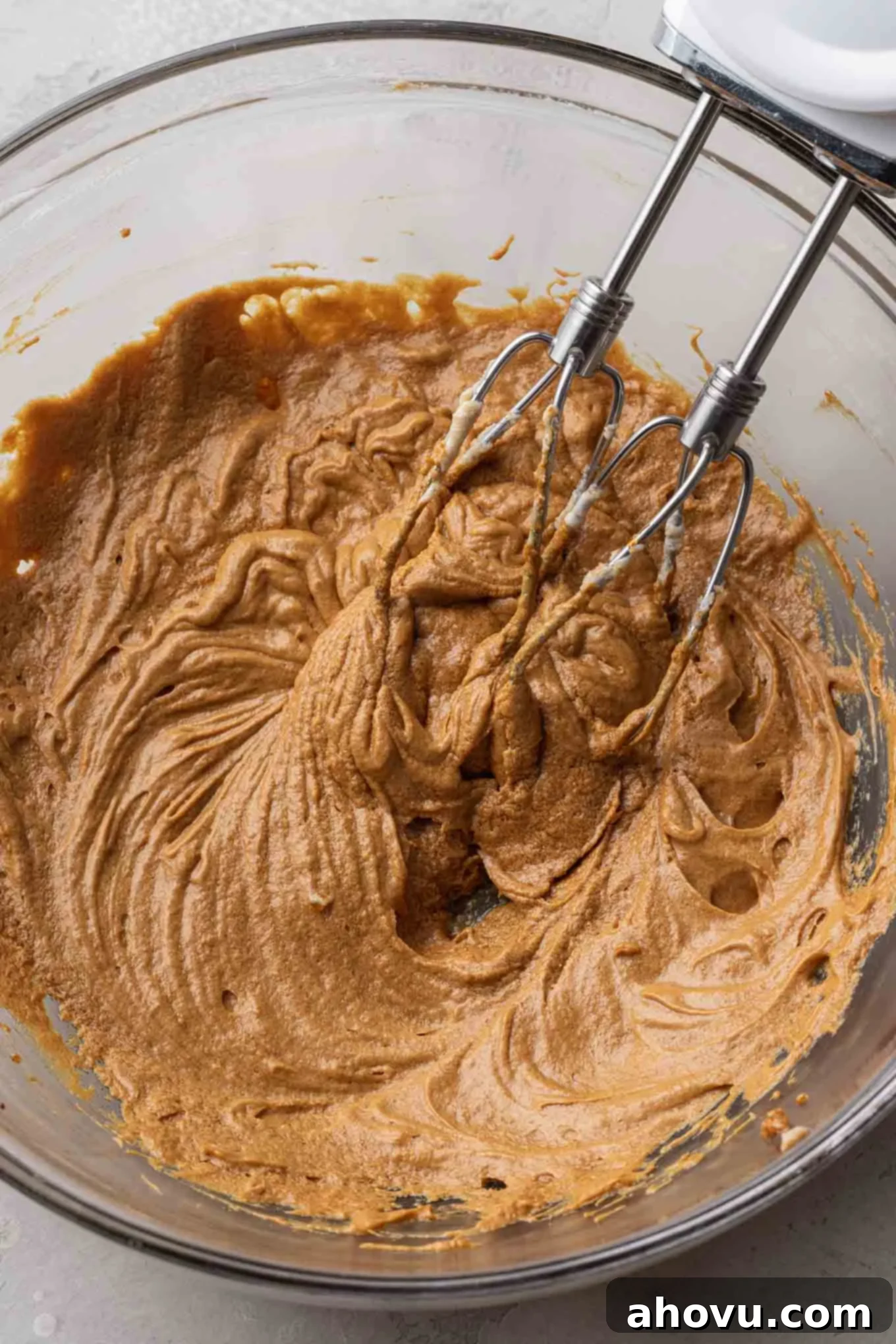 An overhead view of the wet ingredients for gingerbread cupcakes in a glass mixing bowl. 