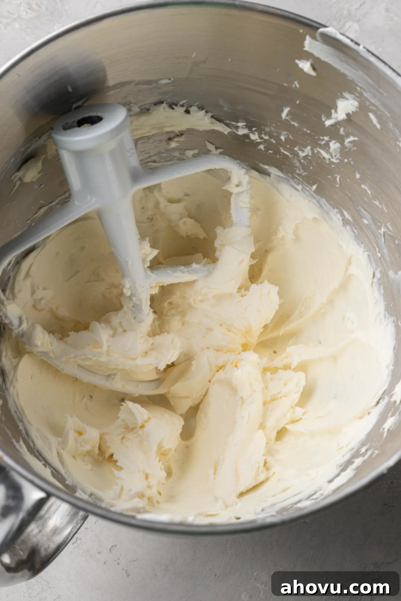 An overhead view of cream cheese and butter in the bowl of a stand mixer. 