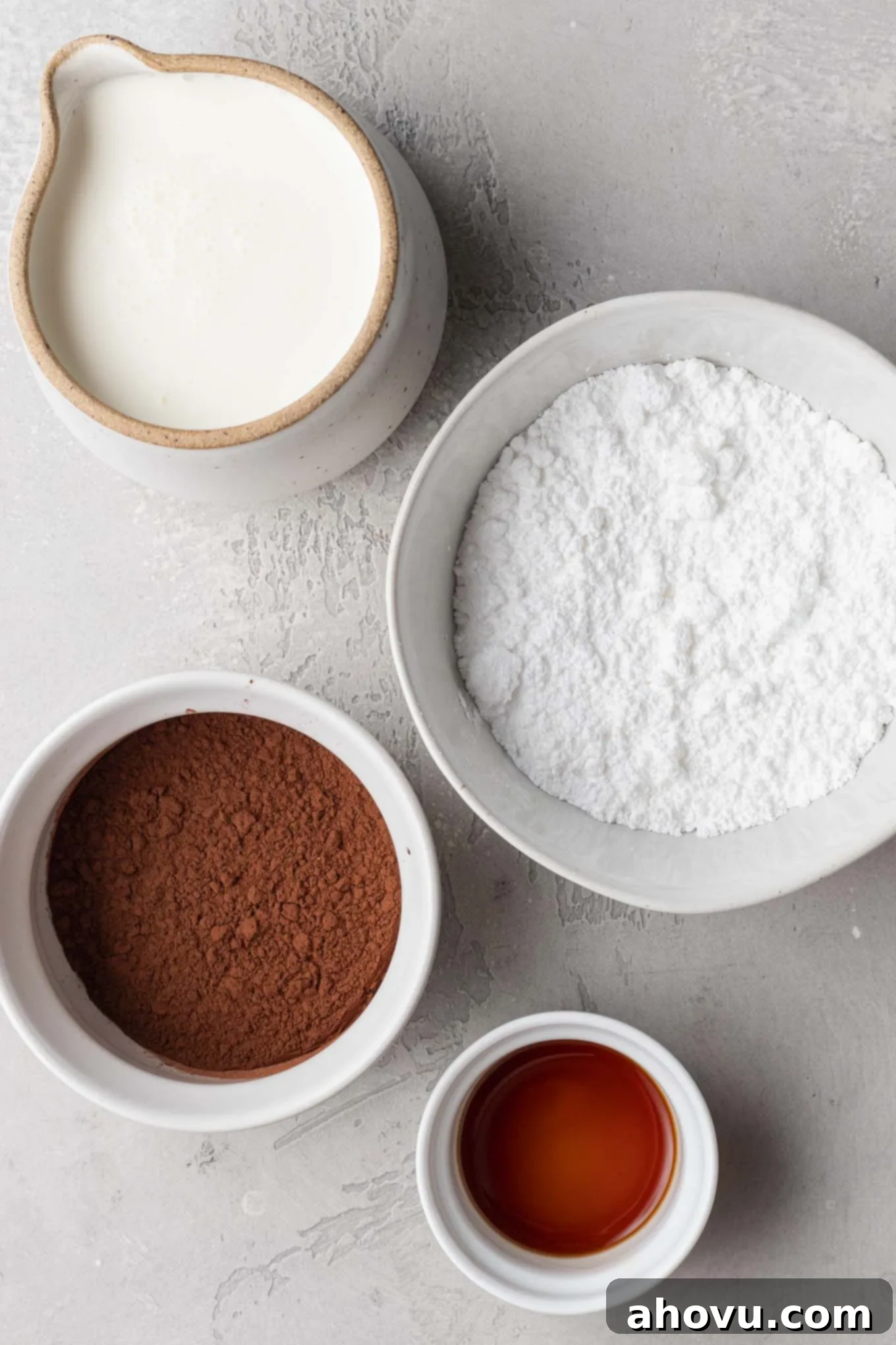 An overhead view of the ingredients needed to make chocolate whipped cream in various bowls and cups.