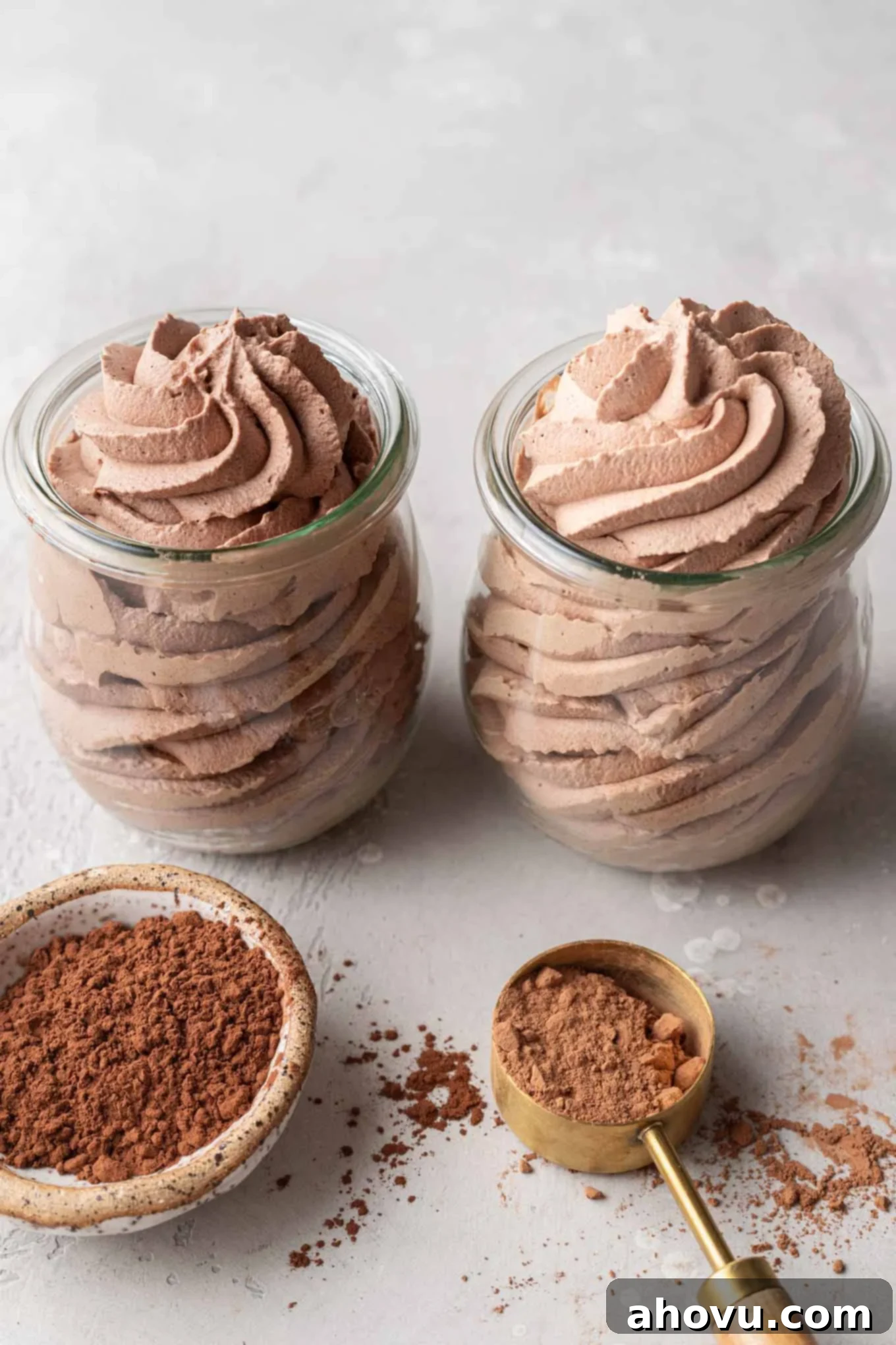 Two small jars filled with chocolate whipped cream. The jar on the left is made with Dutch process cocoa powder and the jar on the right is made with natural cocoa powder.