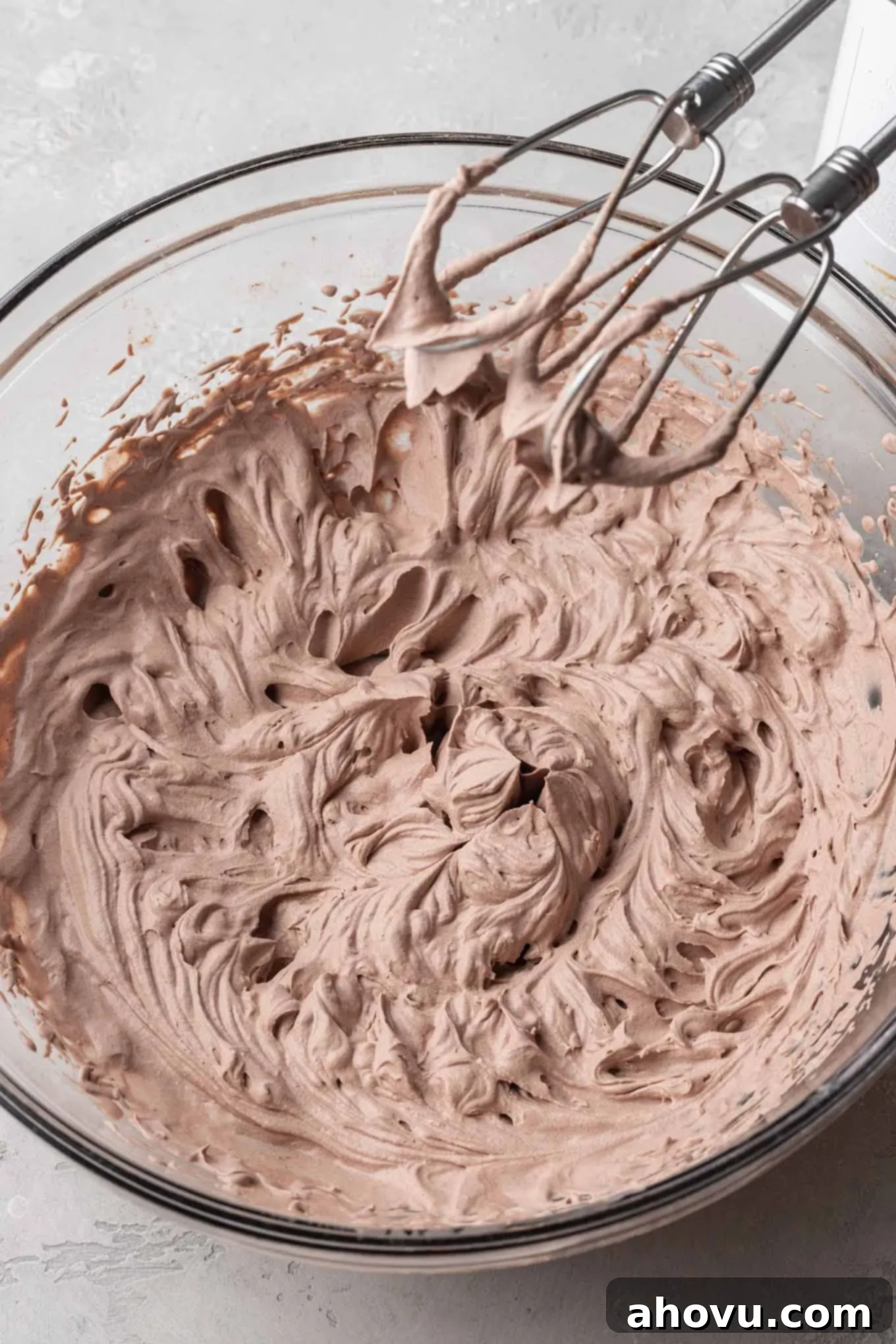 A glass mixing bowl filled with the finished chocolate whipped cream. 