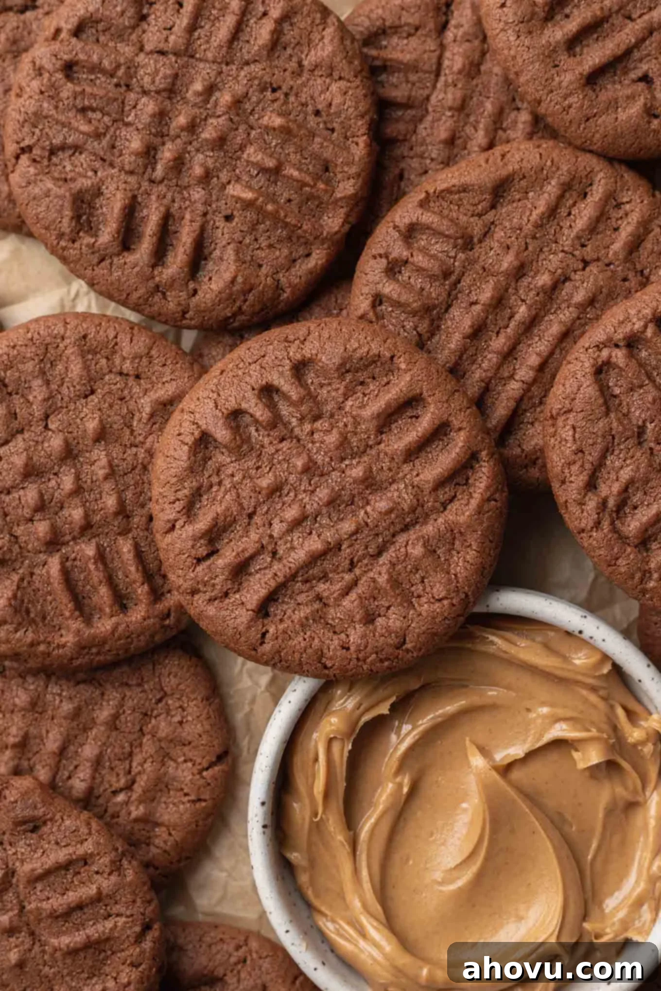 A close-up overhead view of chocolate and peanut butter cookies, with a dish of peanut butter. 