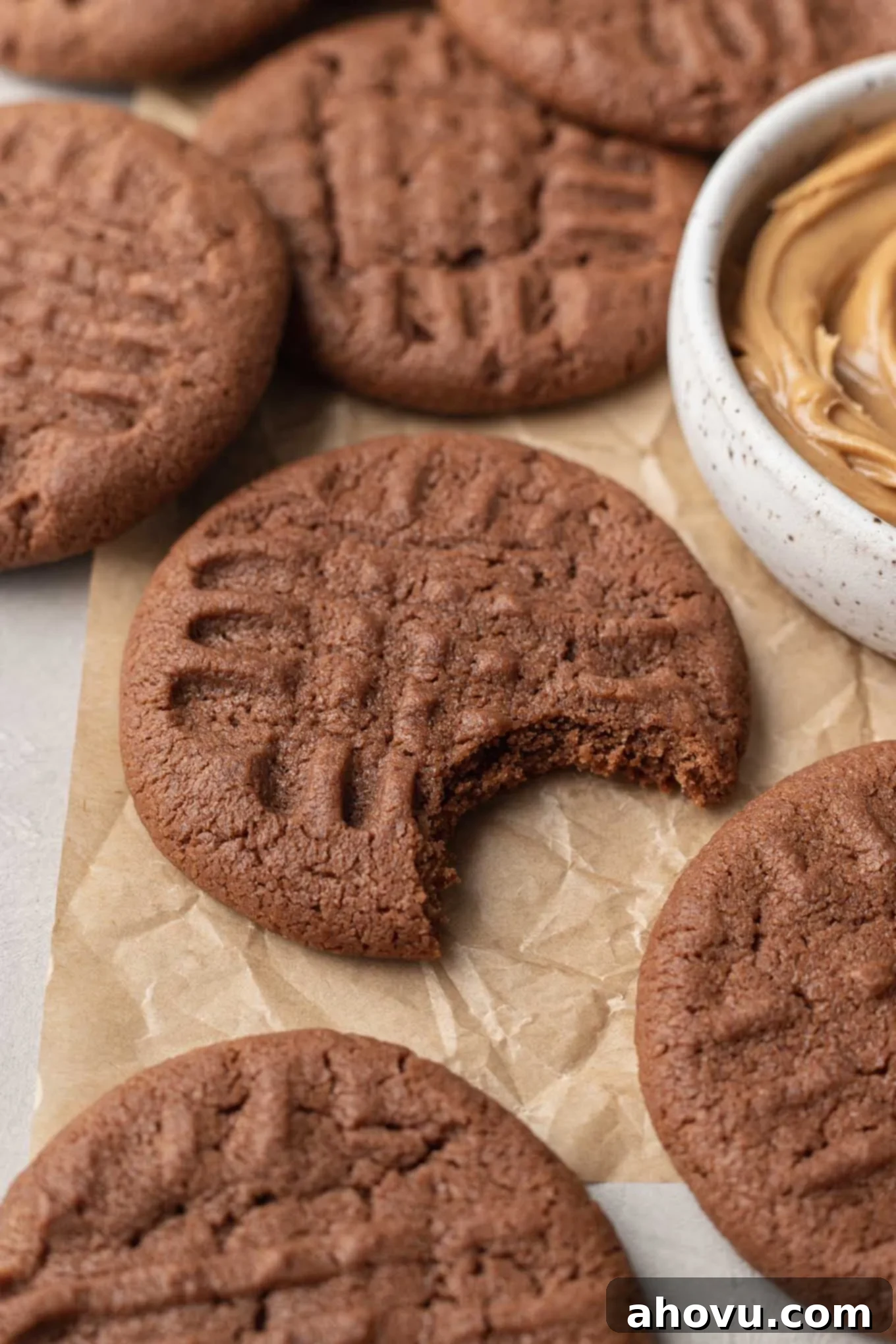 A close-up view of a chocolate peanut butter cookie with a bite missing. 