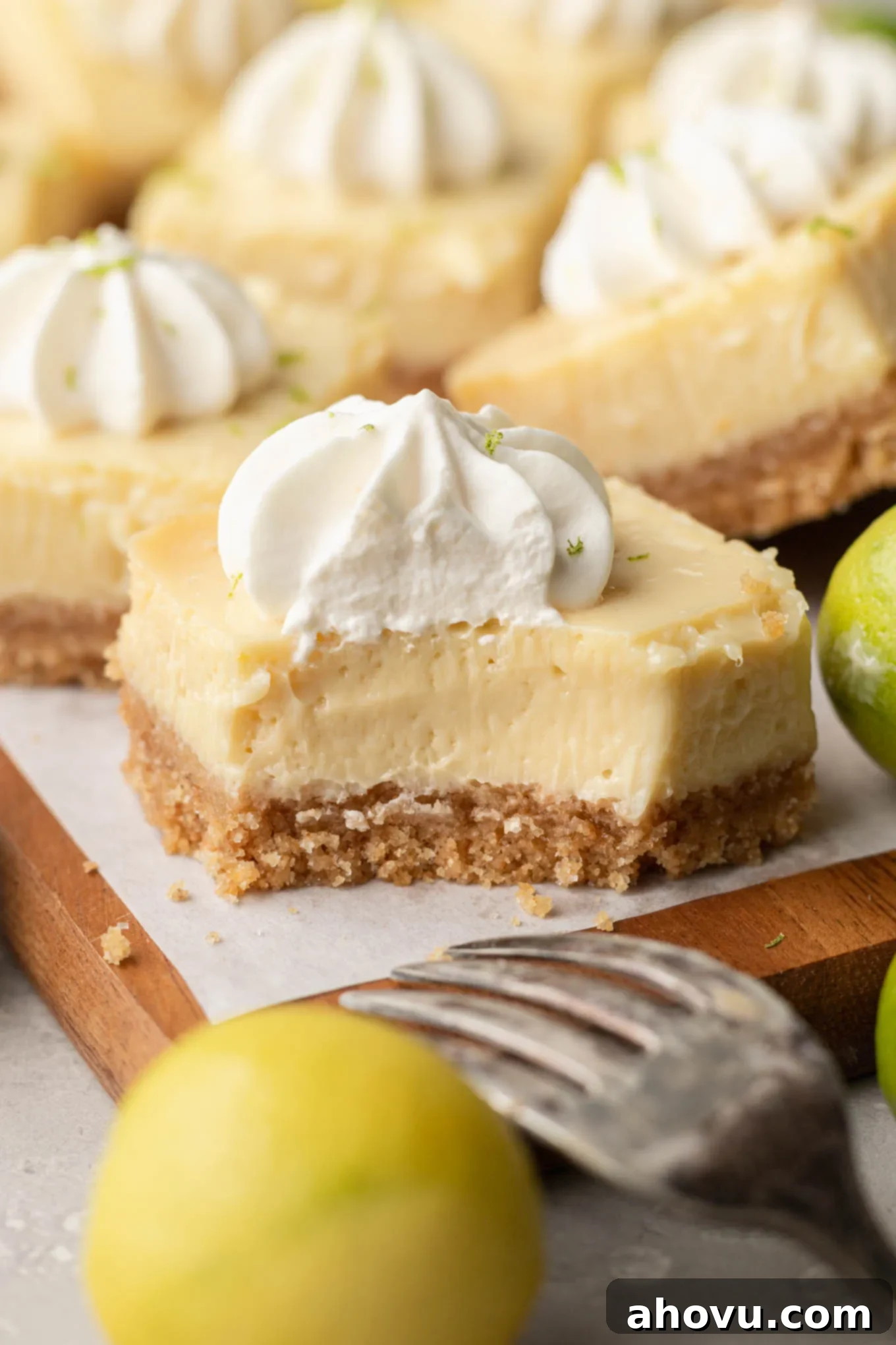 A close-up view of a key lime bar with a bite missing, showing how creamy its filling is. 