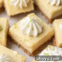 Several sliced key lime pie bars topped with whipped cream.