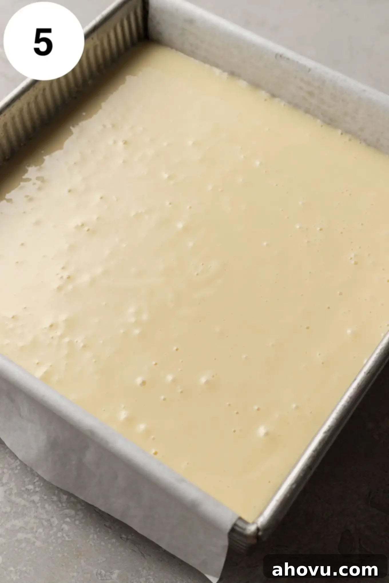 An overhead view of unbaked key lime bars in a square baking dish. 