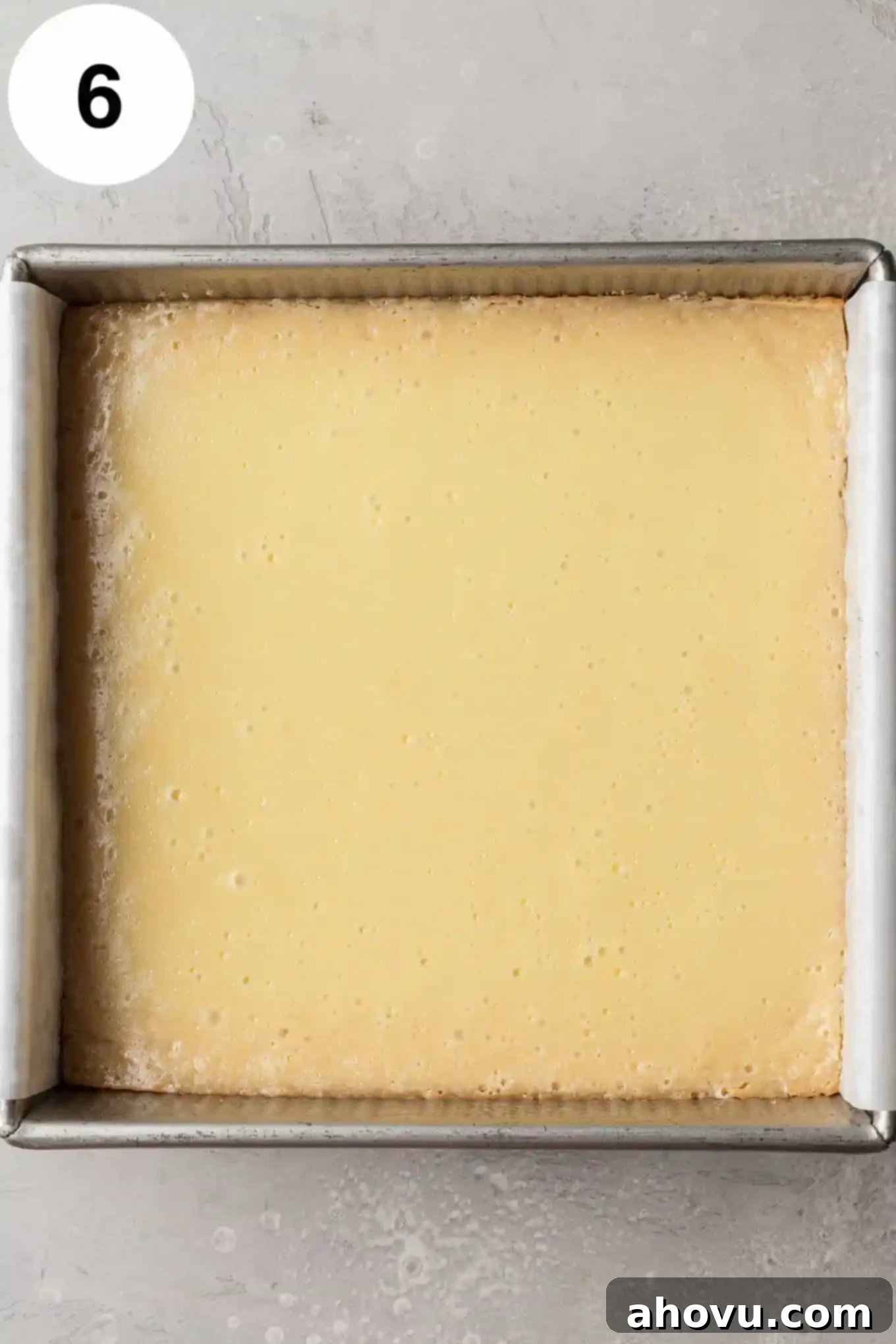 An overhead view of baked key lime bars in a square baking dish. 