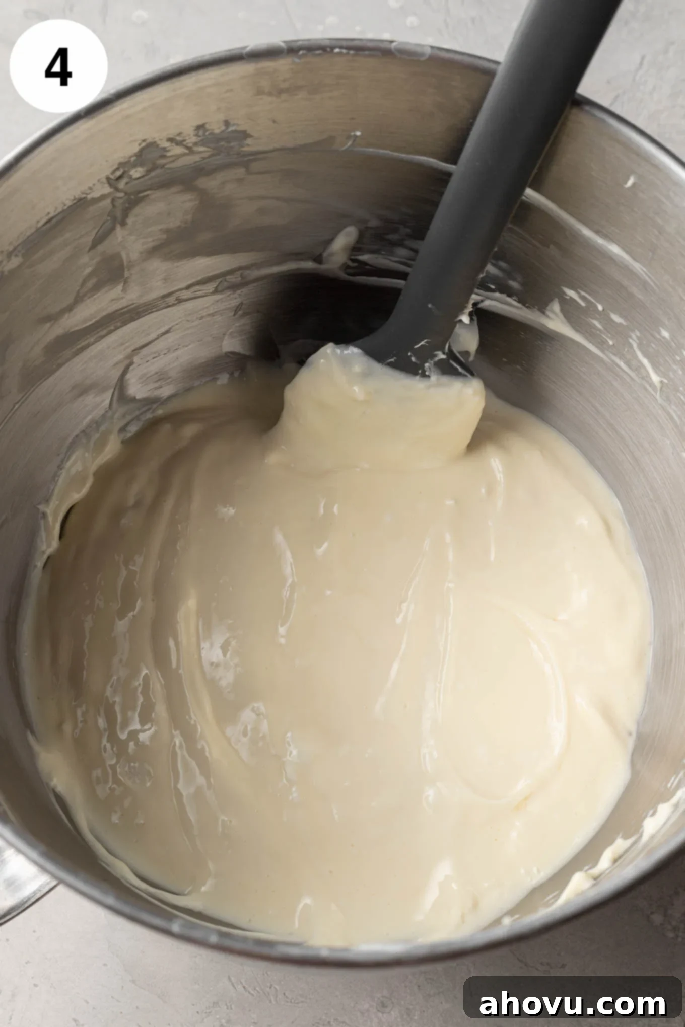 Creamy Cheesecake Squares 7 An overhead view of cheesecake filling in the bowl of a stand mixer, with a rubber spatula.