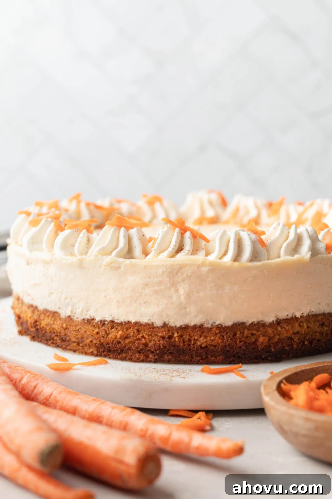 A side view of a layered carrot cake cheesecake, showing the distinct carrot cake and cheesecake layers.
