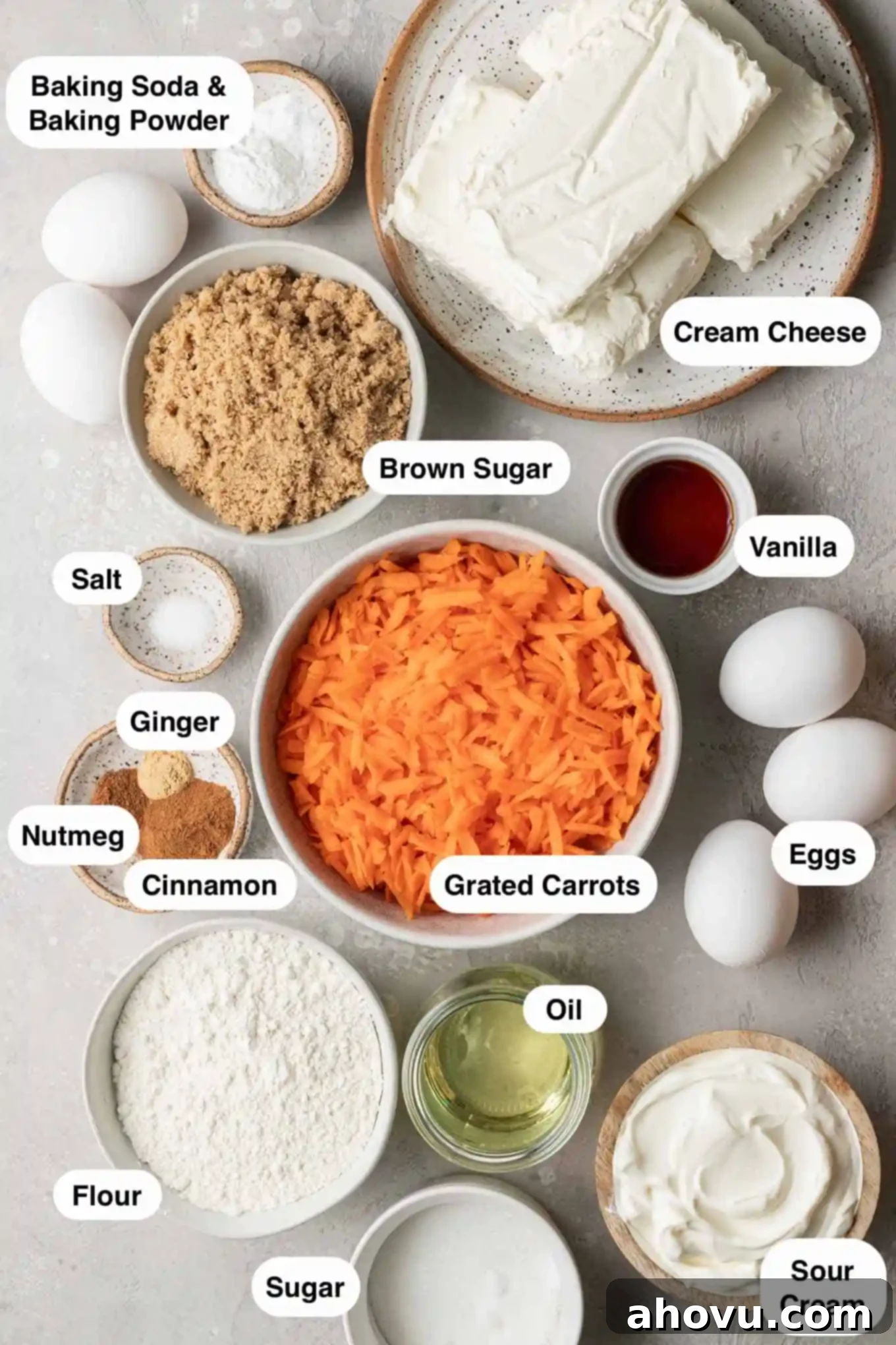An overhead view of the carefully arranged ingredients needed to make a carrot cake cheesecake, including spices, flours, carrots, and dairy.