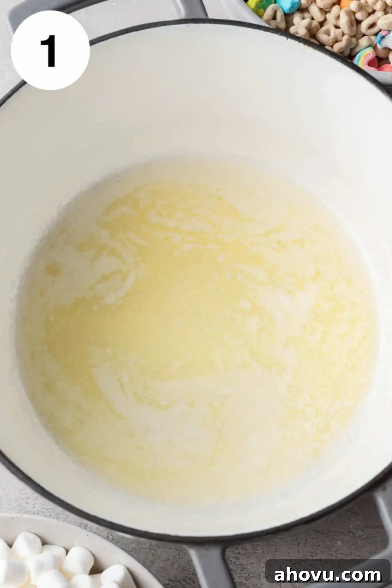 Lucky Charms Treats 4 An overhead view of melted butter shimmering in a large saucepan over low heat.