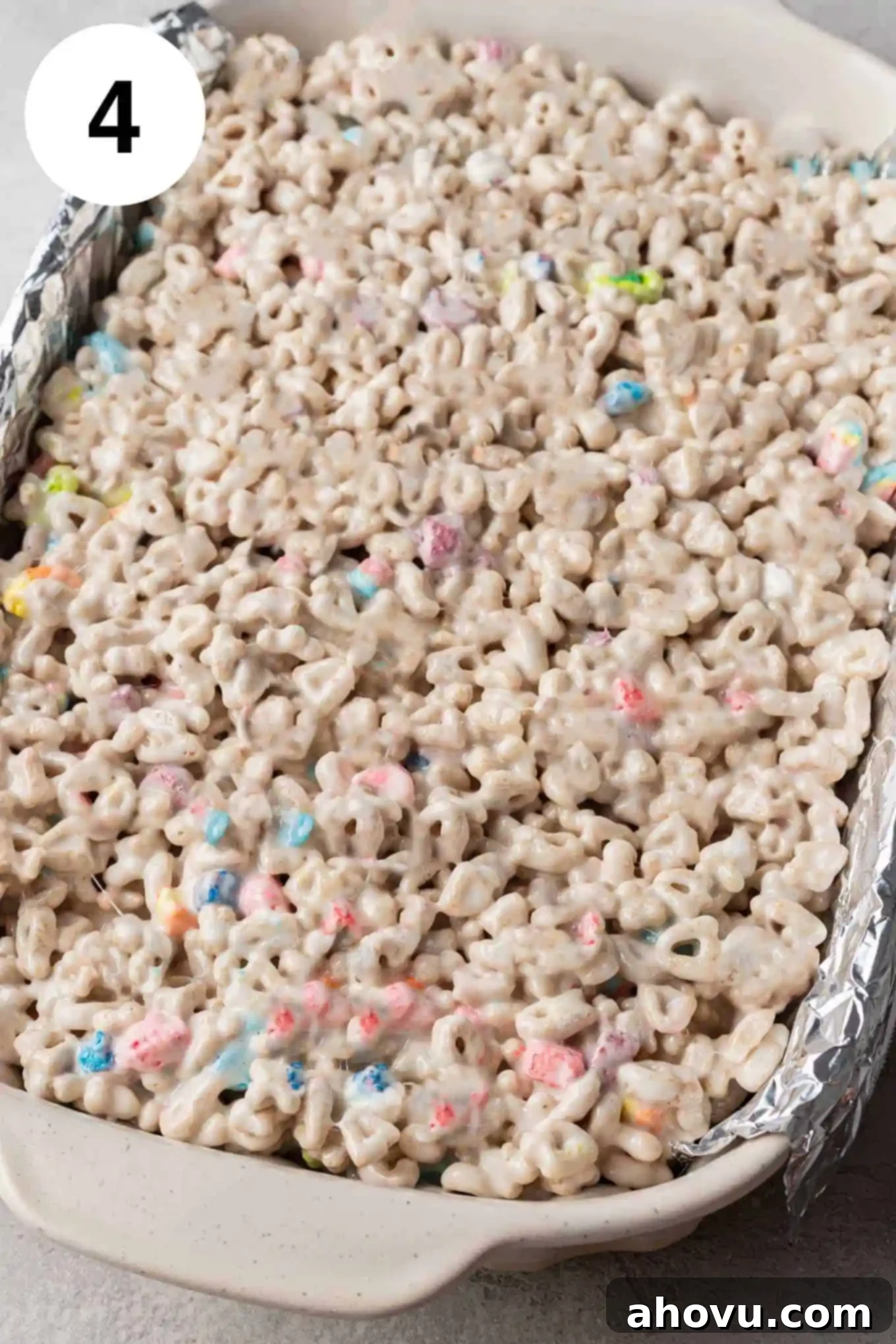 Lucky Charms Treats 7 An overhead view of the freshly prepared Lucky Charms treat mixture pressed firmly into a greased 9x13-inch pan, ready for cooling.