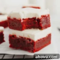 Two red velvet brownies stacked on top of each other. The top brownie has a bite missing.