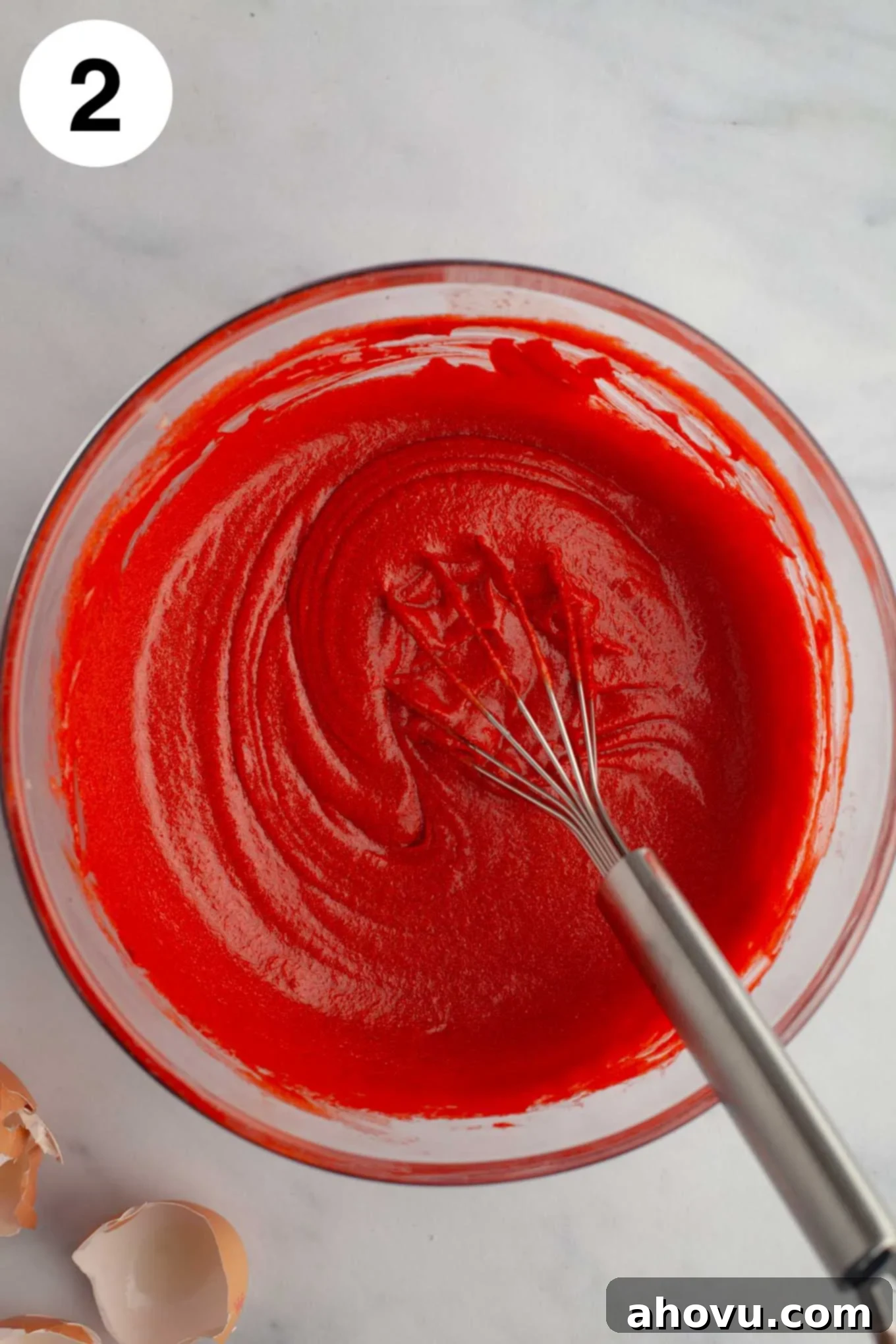 Eggs, red food coloring, and vanilla extract mixed into the melted butter and sugar.